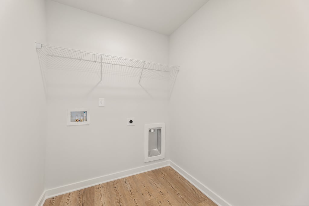 A white room with a wood floor.
