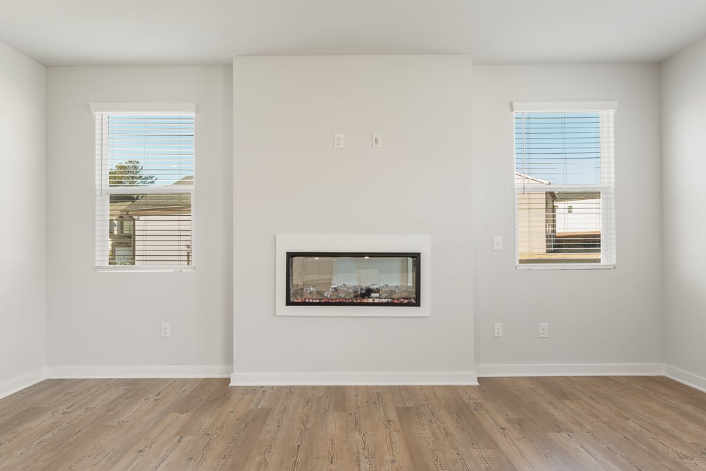 A room with windows and a wood floor.