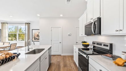 A kitchen with white cabinets.