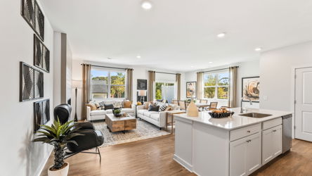 A large living room with a large kitchen and a large window.
