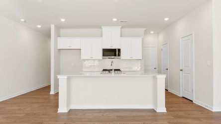 A kitchen with white cabinets.