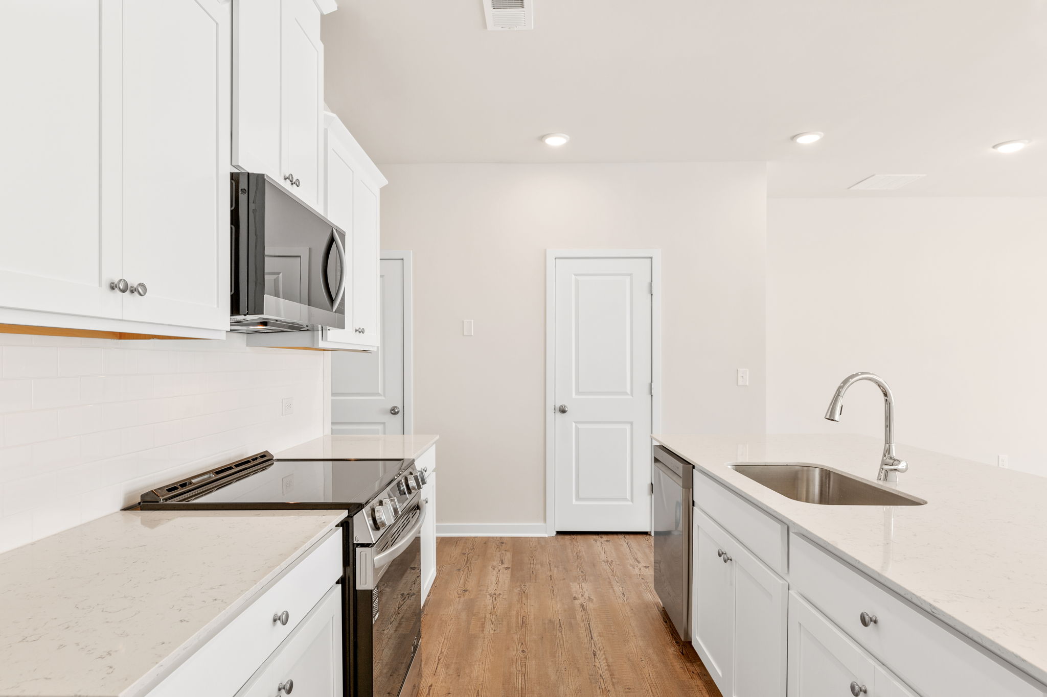 A kitchen with white cabinets.