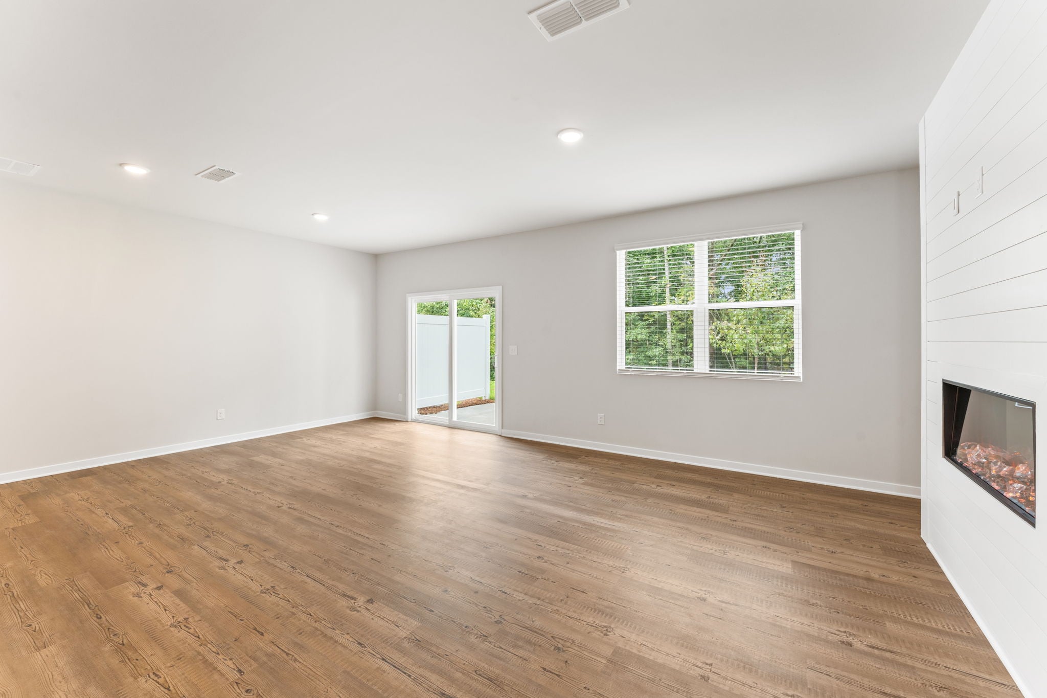 A room with a wood floor and a window with a wood floor.