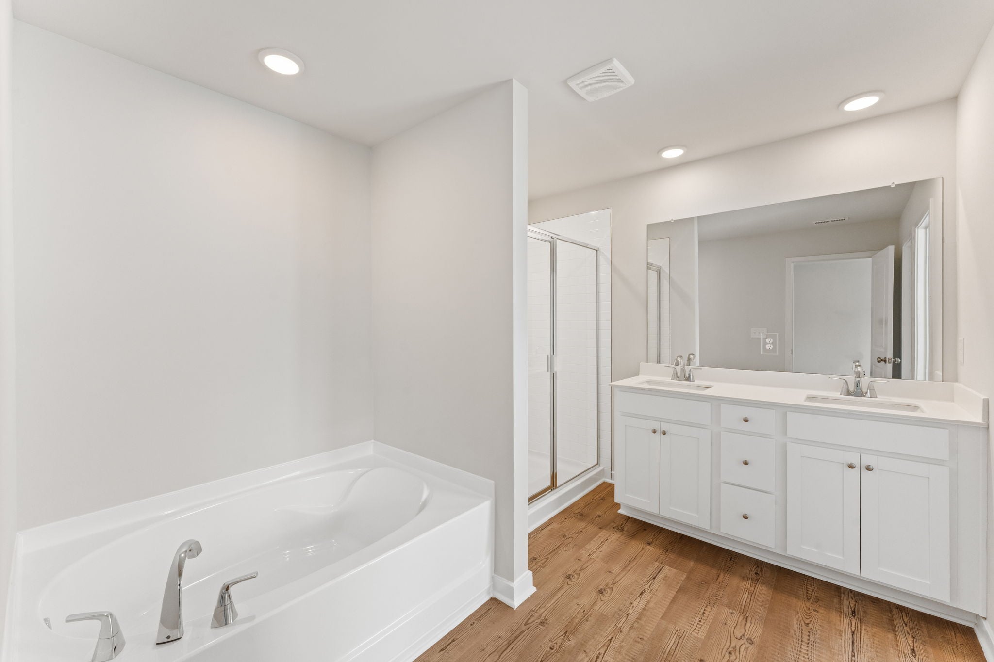 A bathroom with a tub sink and a mirror.