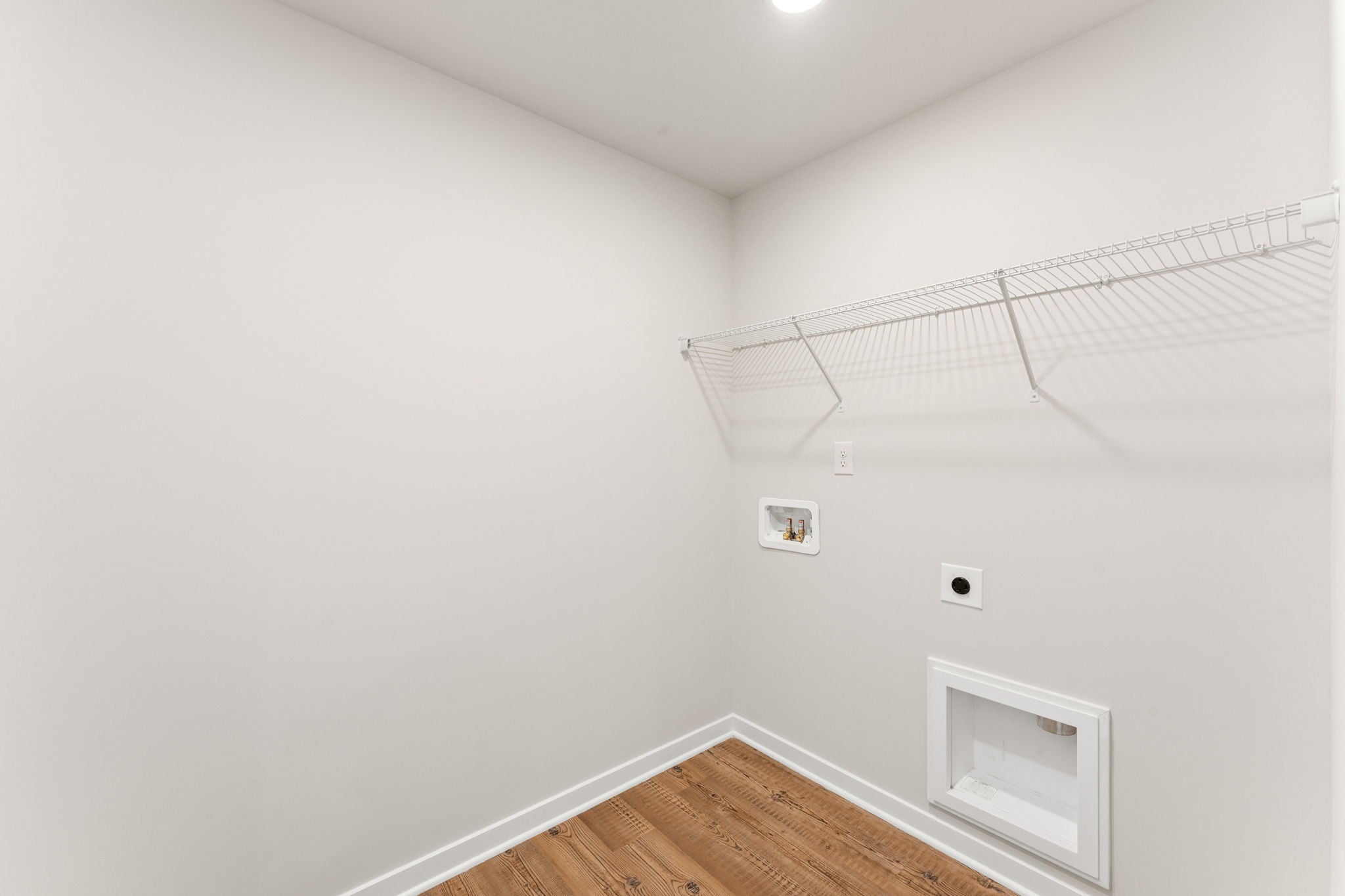 A room with a wood floor and white walls.