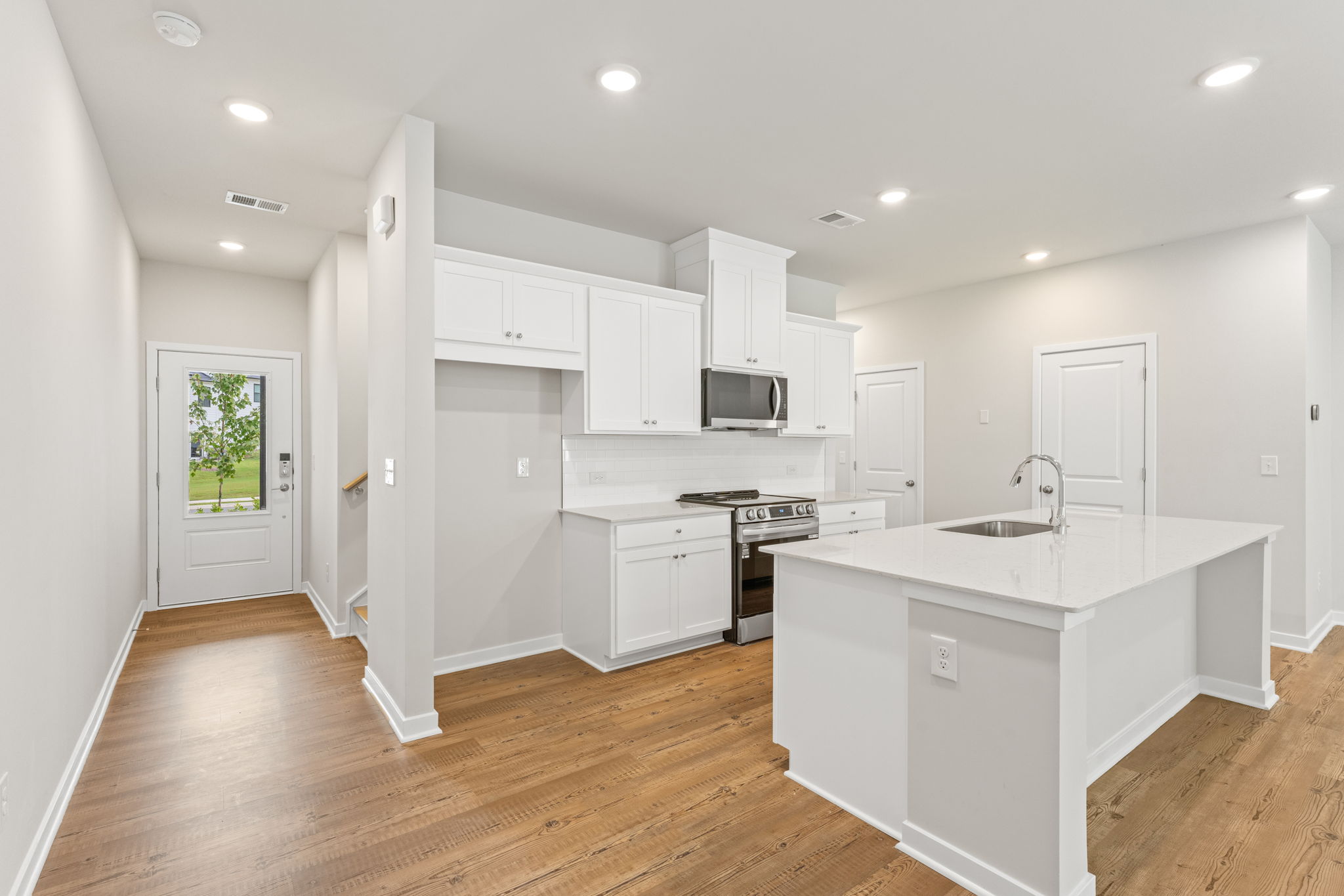 A kitchen with white cabinets.
