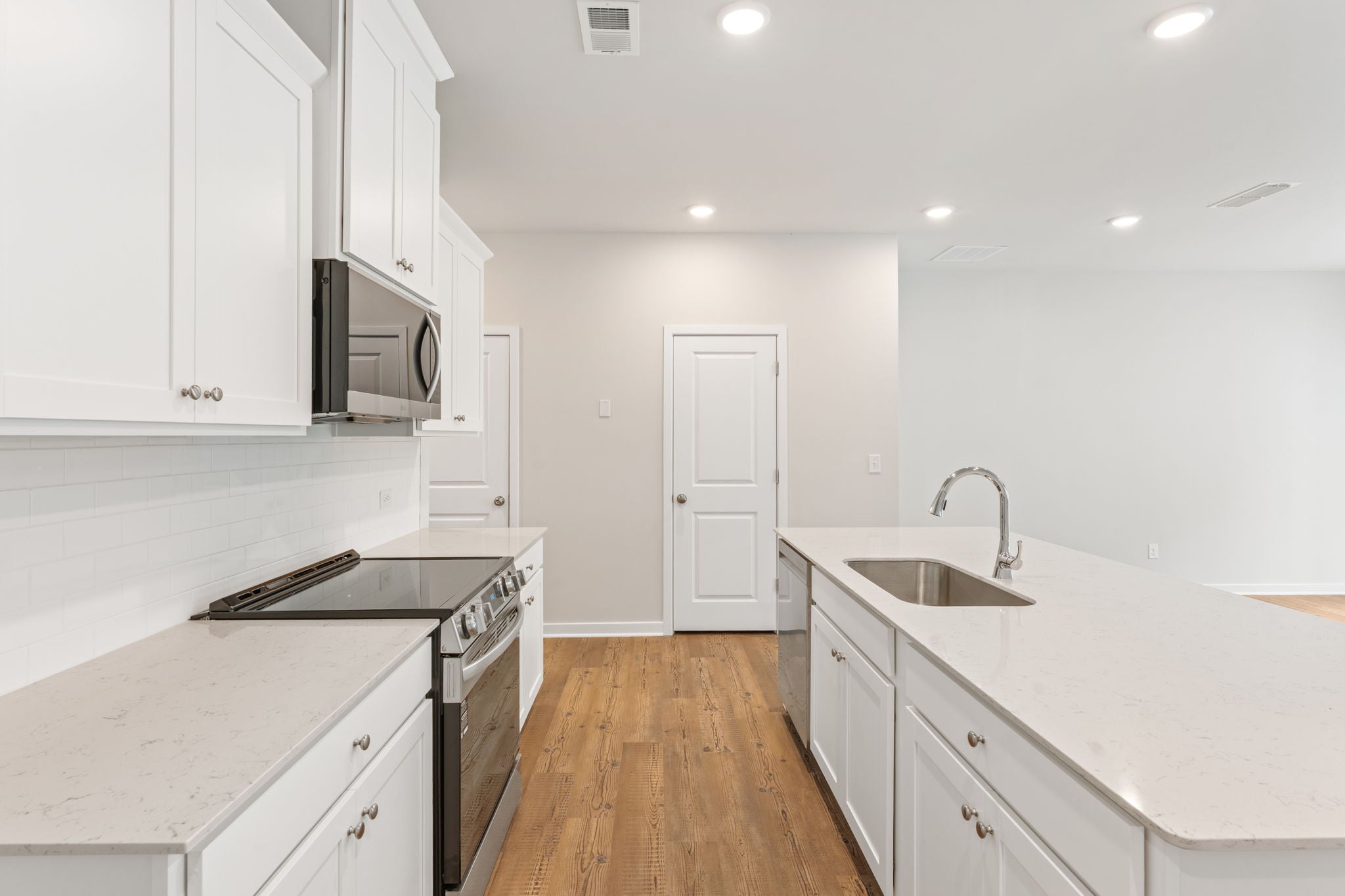 A kitchen with white cabinets.