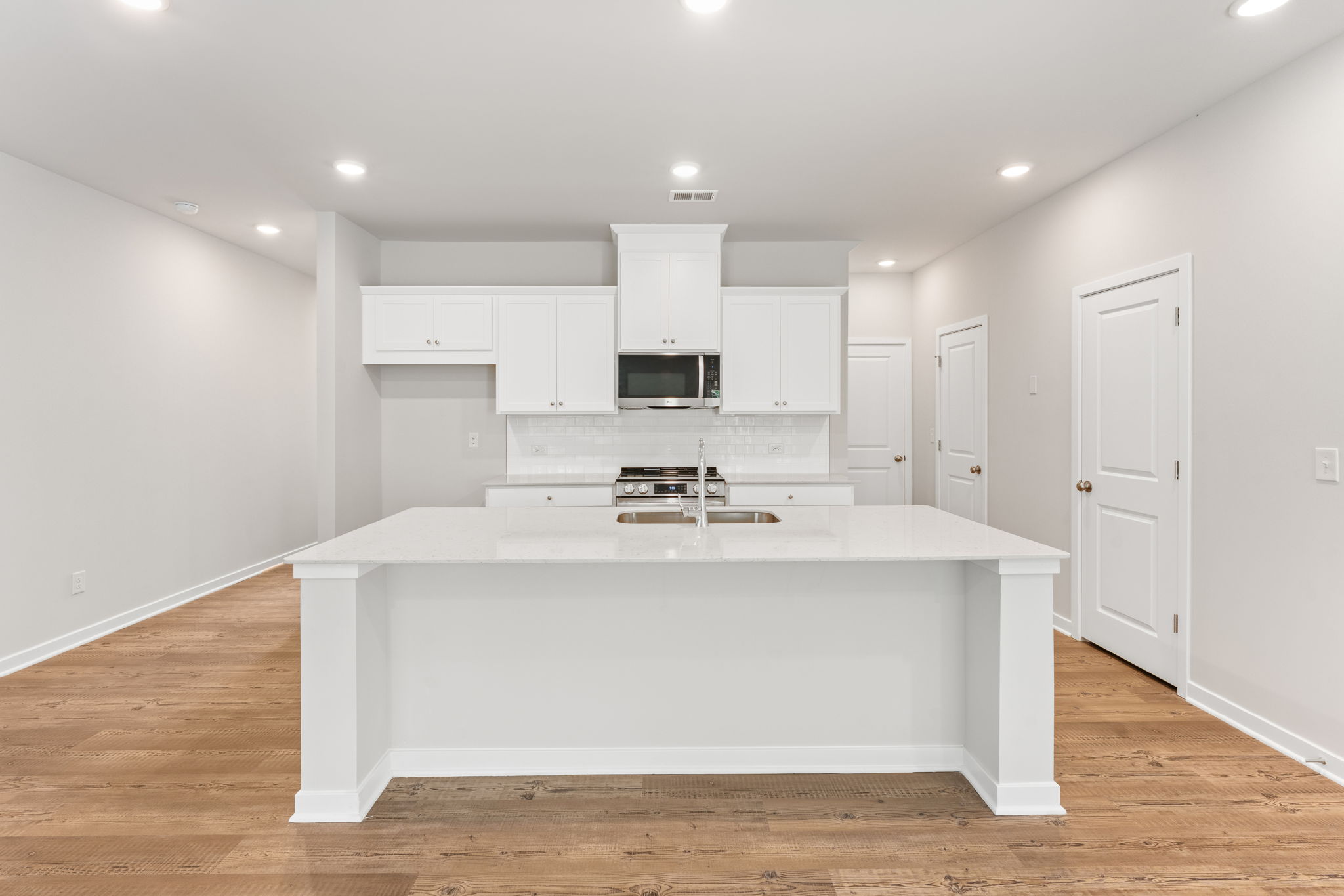A kitchen with white cabinets.