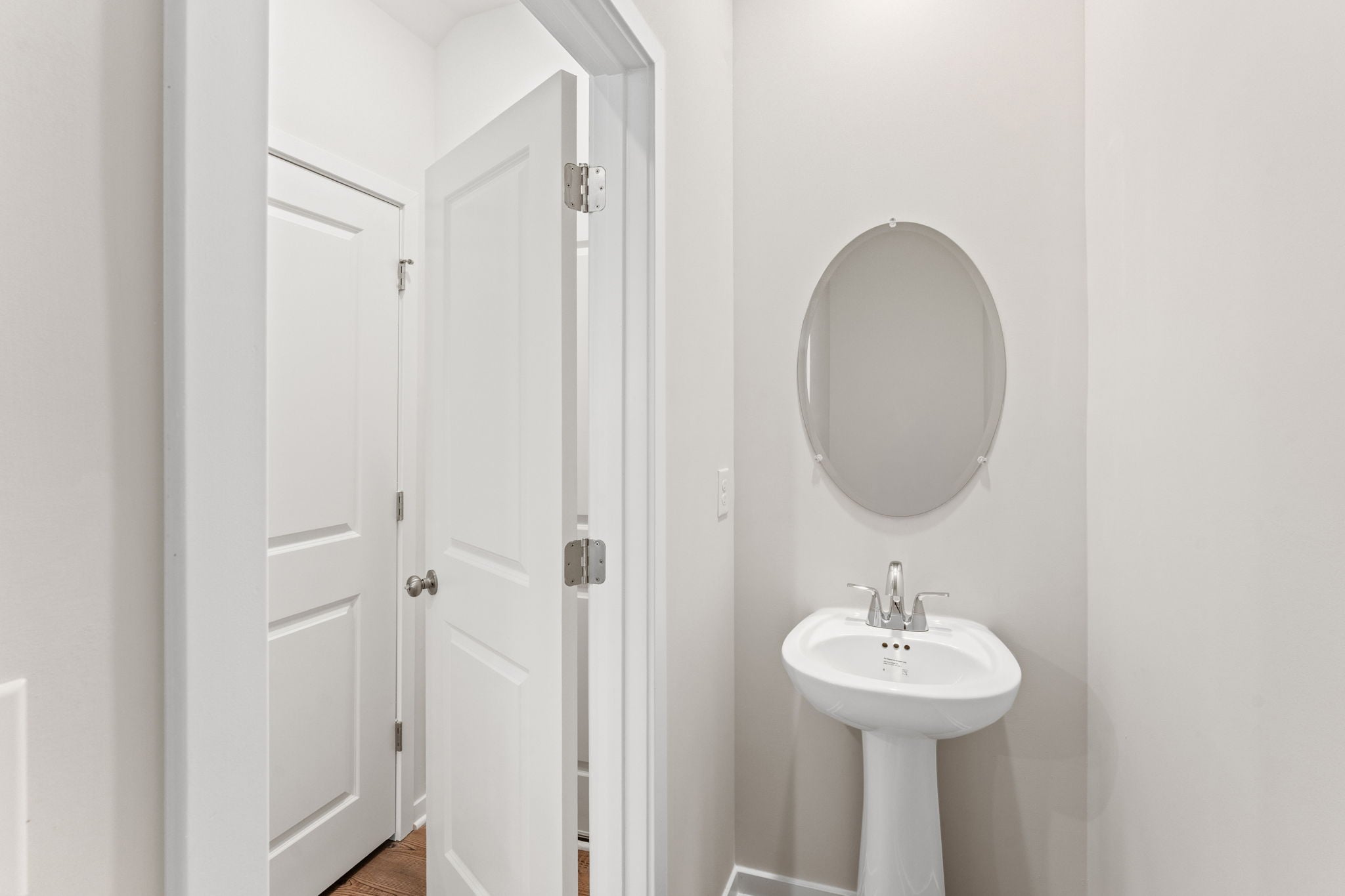 A bathroom with a round mirror.