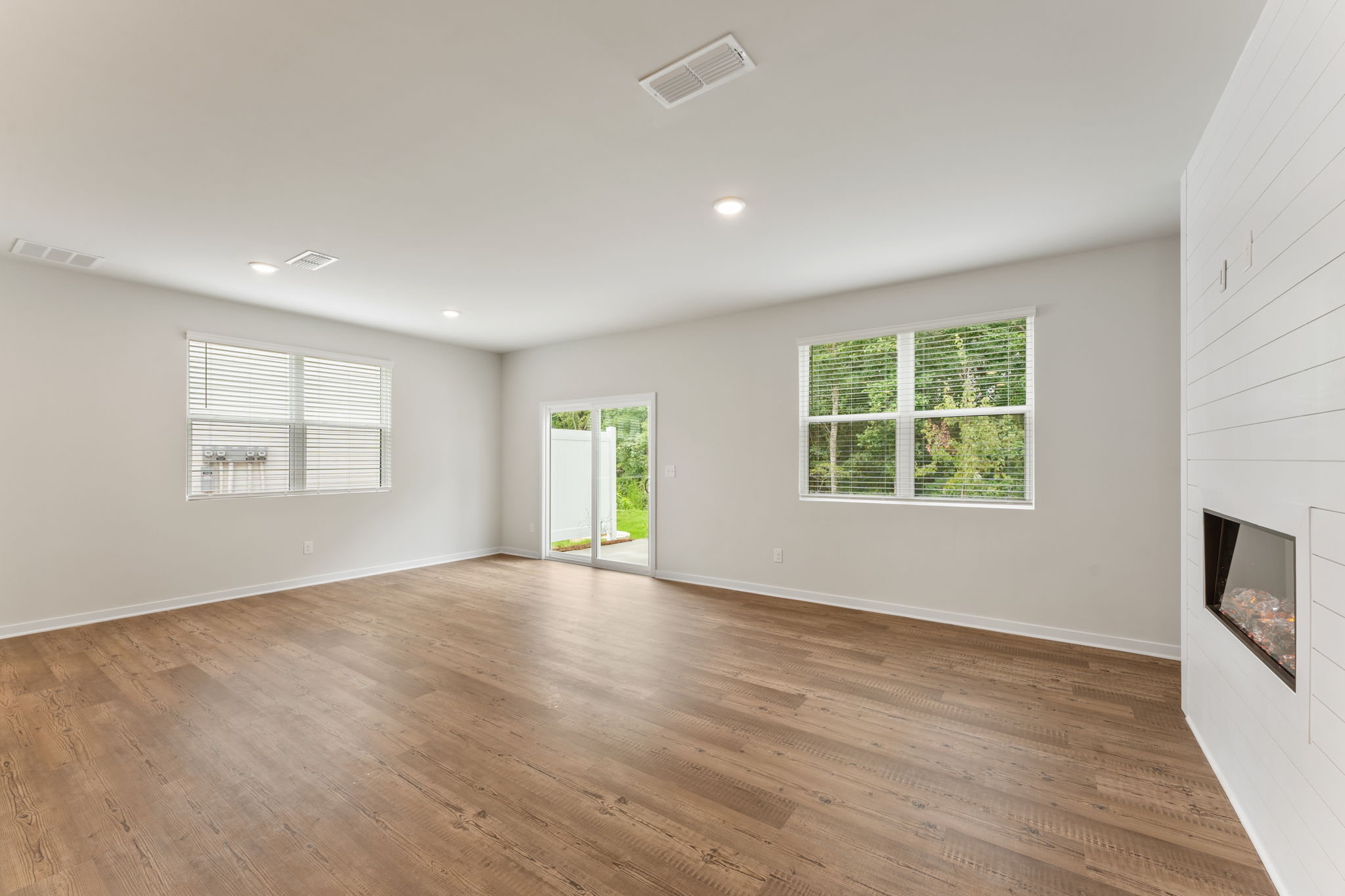A room with a wood floor and windows.