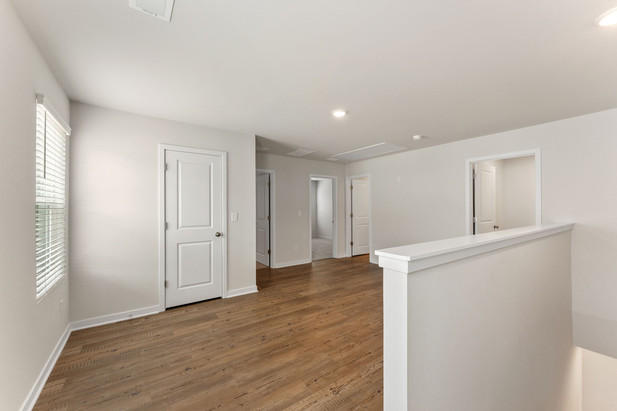 A room with white walls and wood floors.