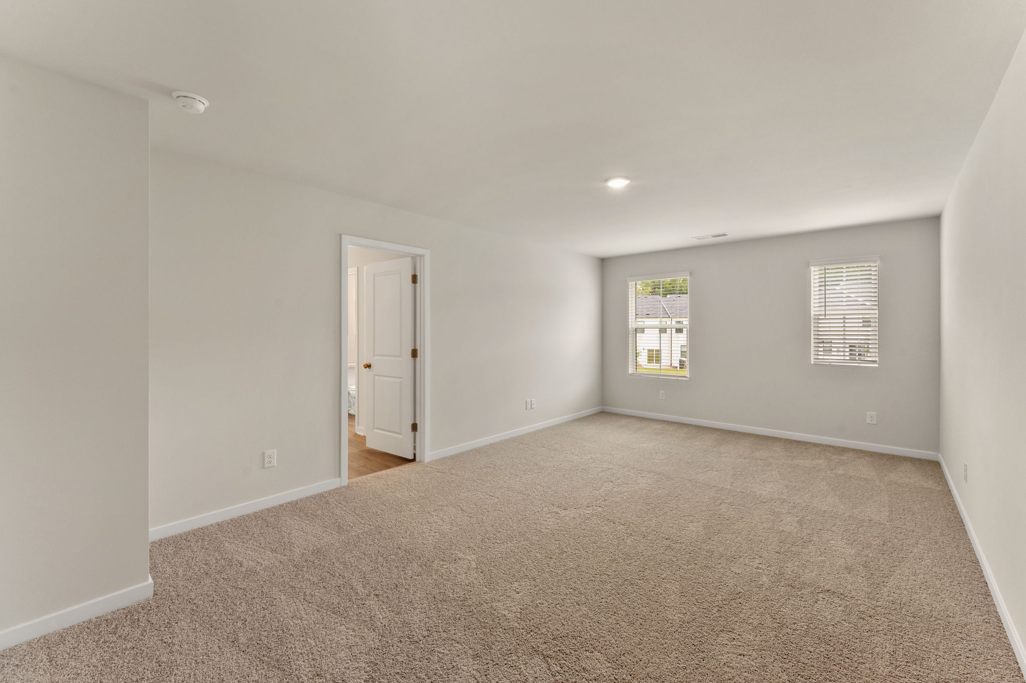 A room with a carpet and a door.