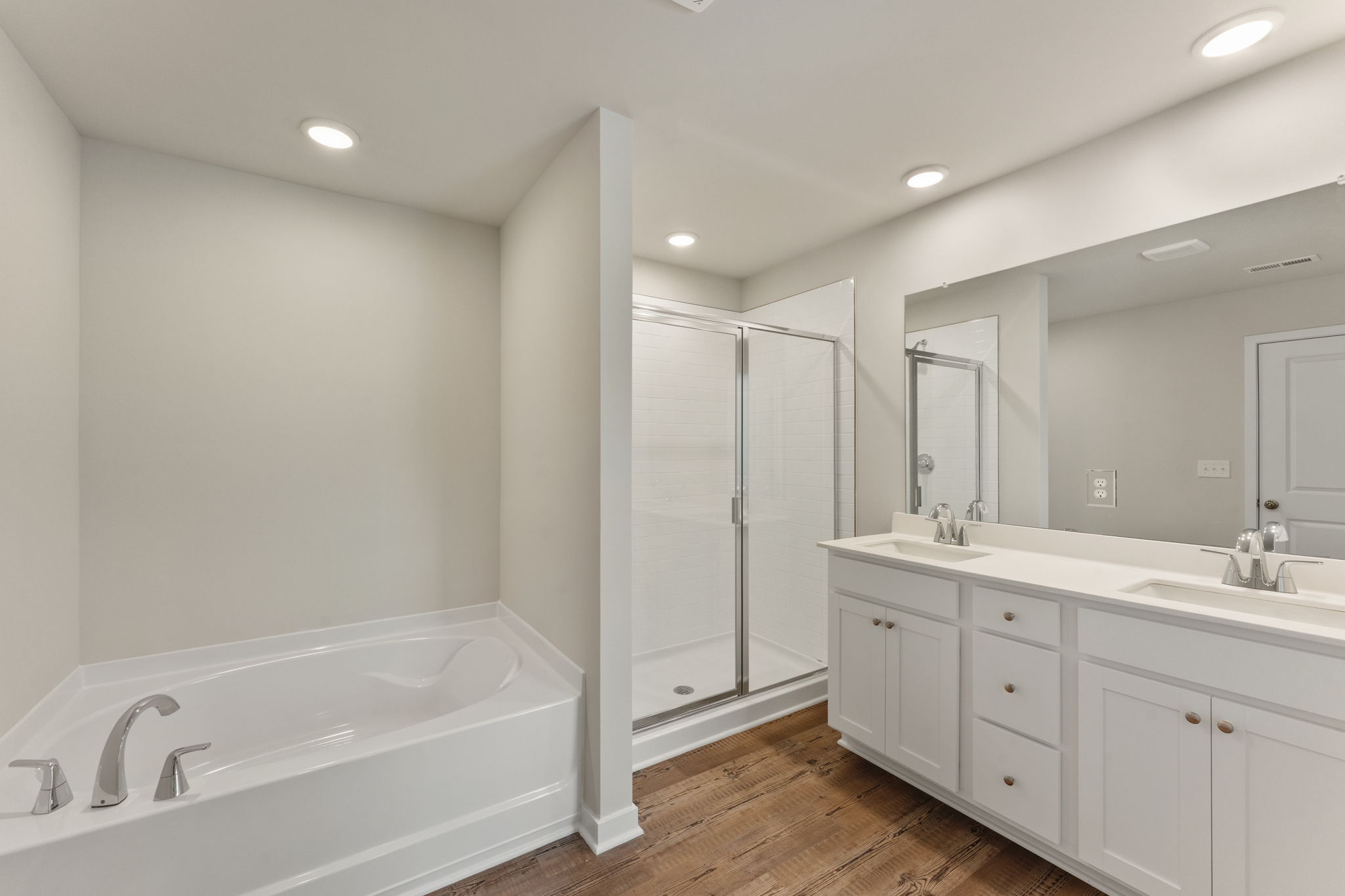 A bathroom with a tub sink and shower.