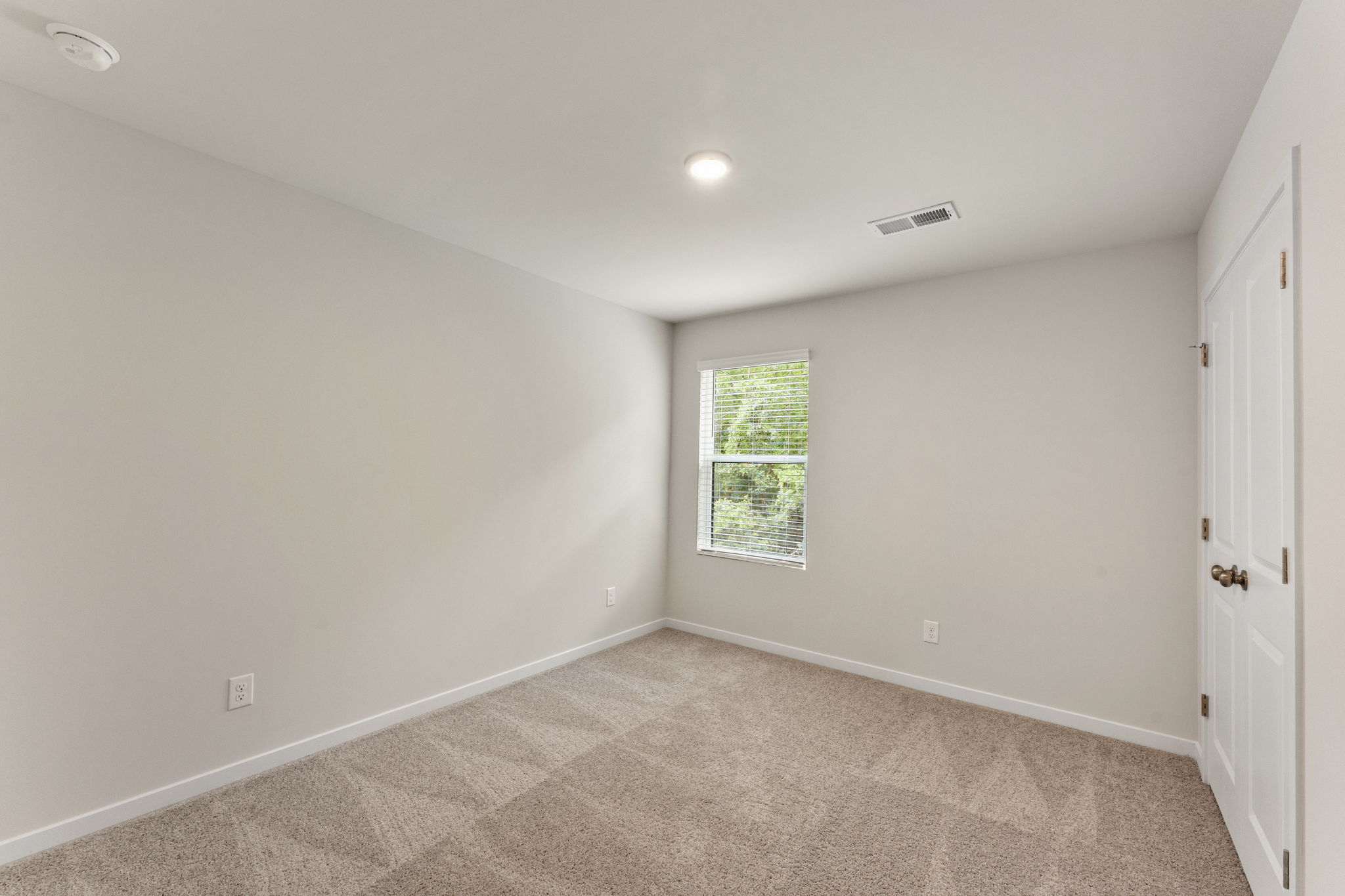 A room with a carpet and a window.