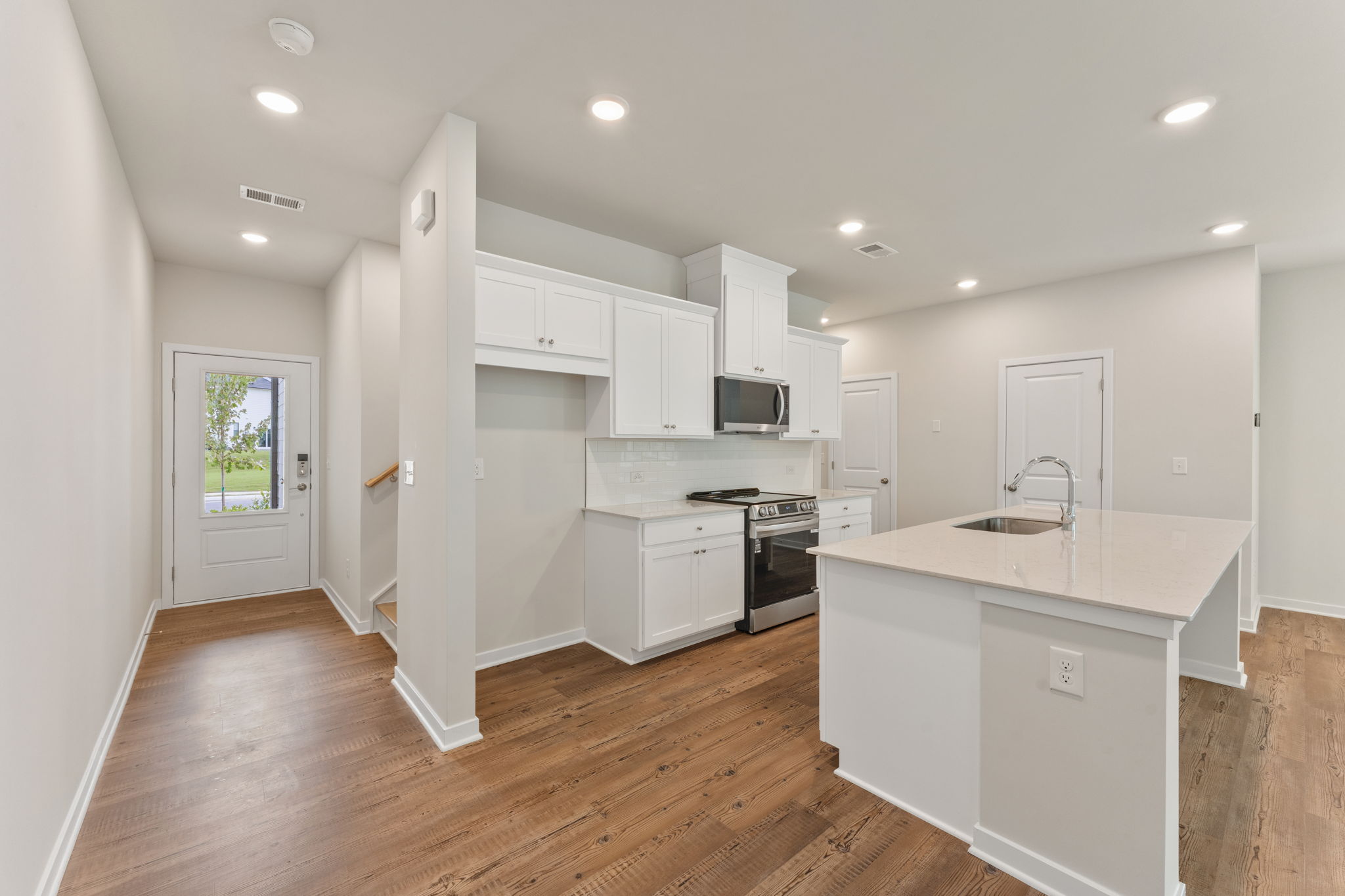 A kitchen with white cabinets.