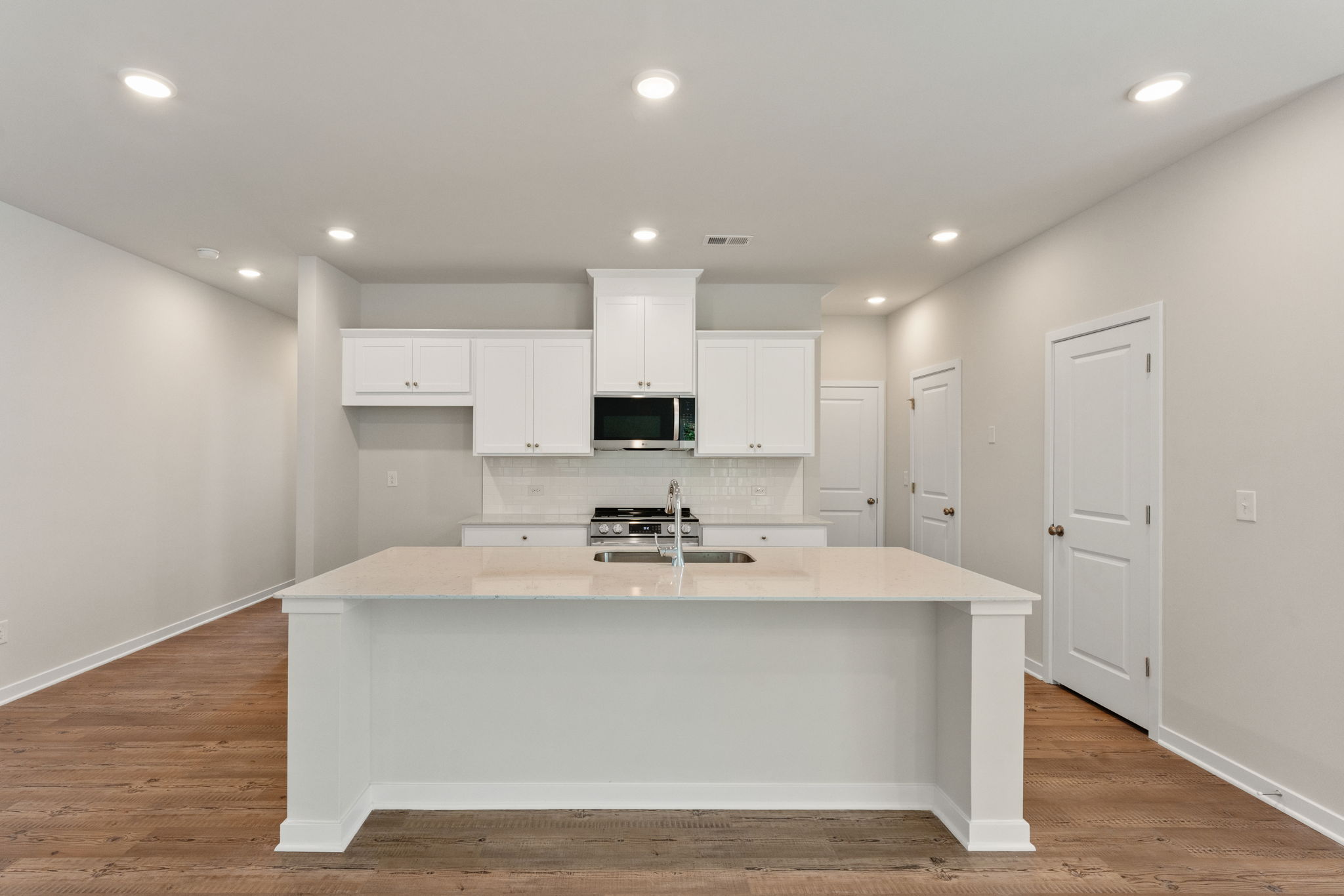 A kitchen with white cabinets.