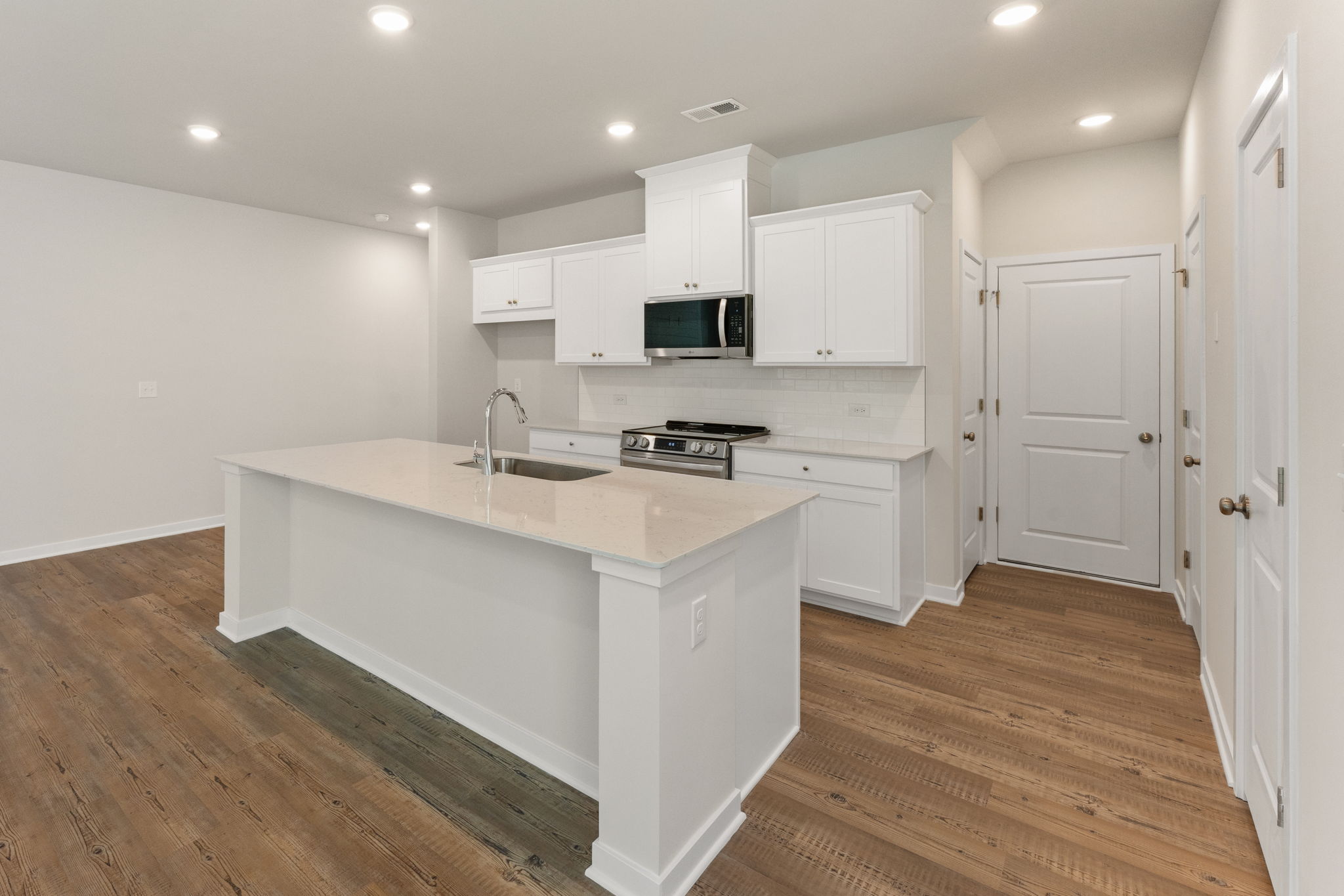 A kitchen with white cabinets.