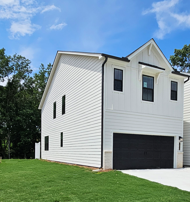 A white house with a garage with Rockingham Meeting House in the background.