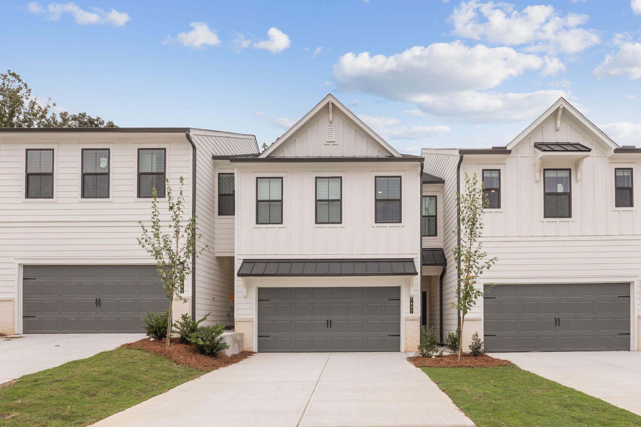 A white house with garages.