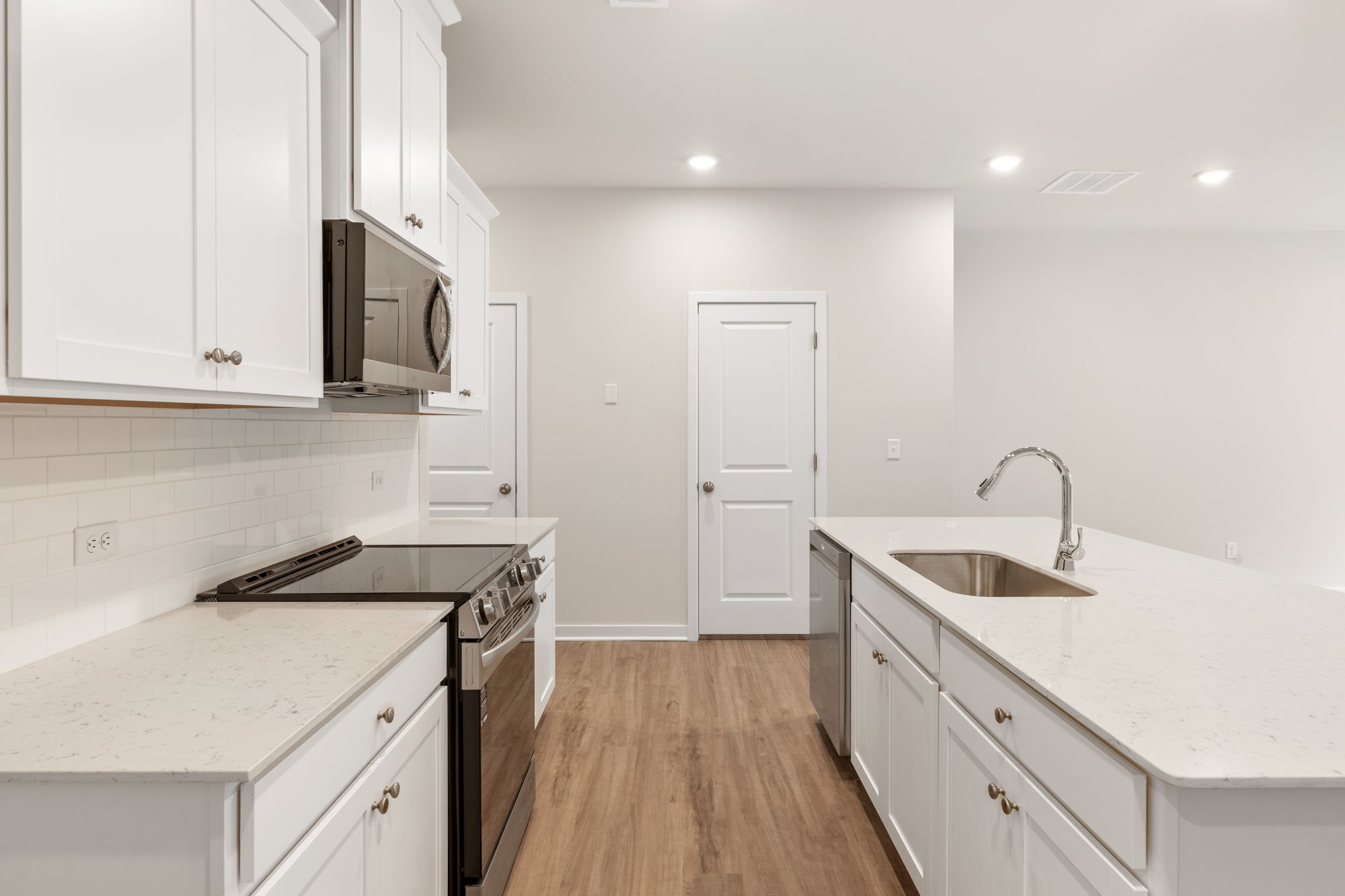 A kitchen with white cabinets.