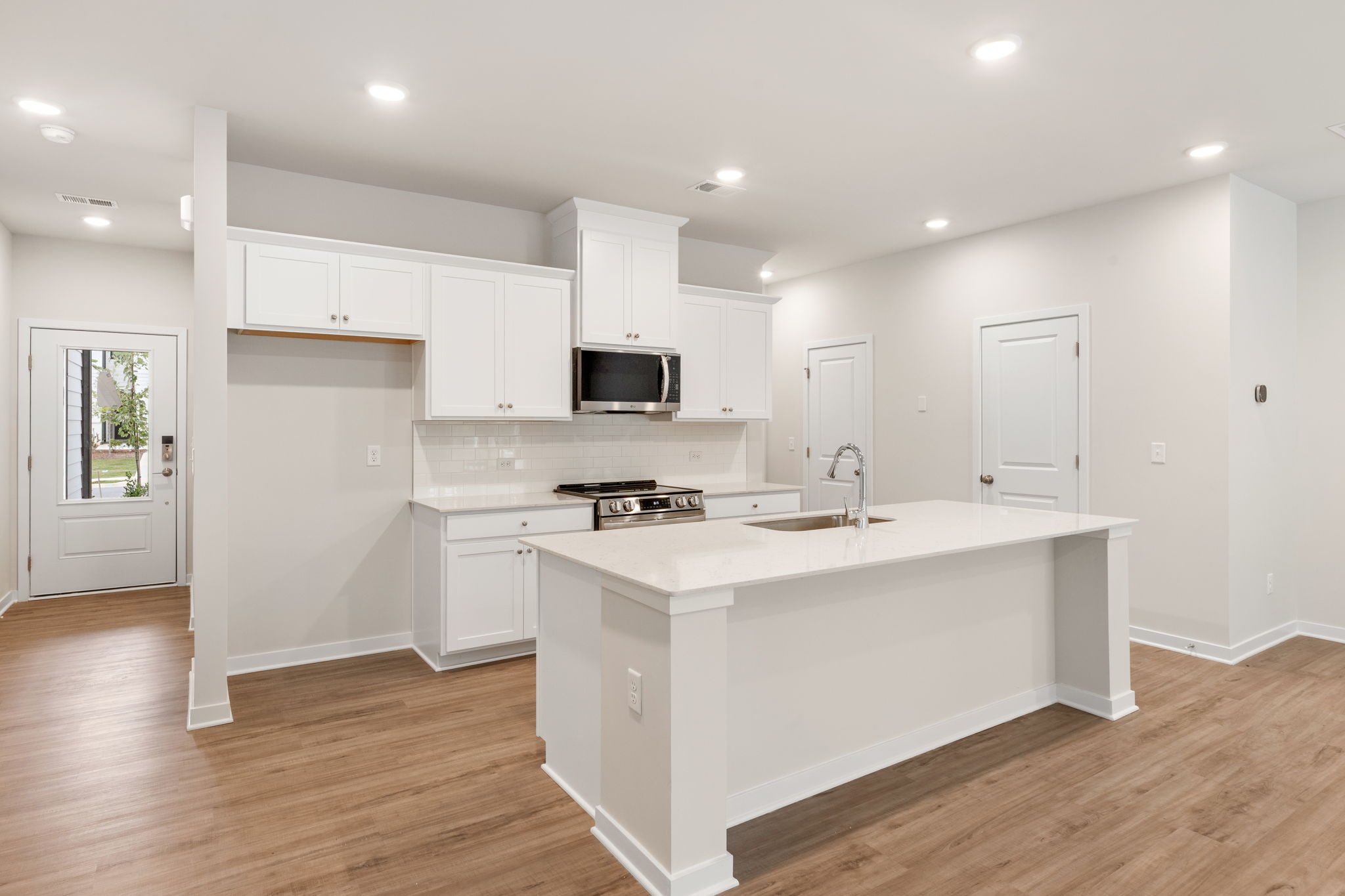 A kitchen with white cabinets.
