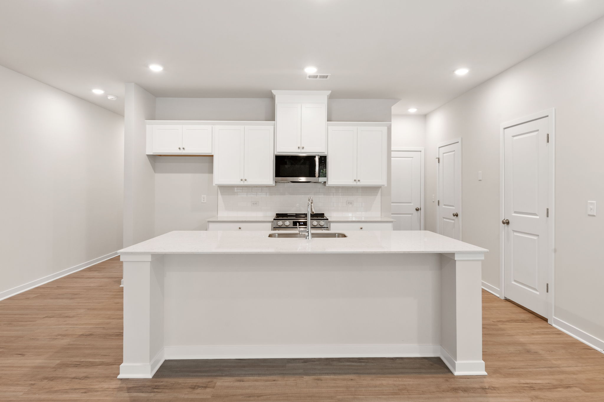 A kitchen with white cabinets.
