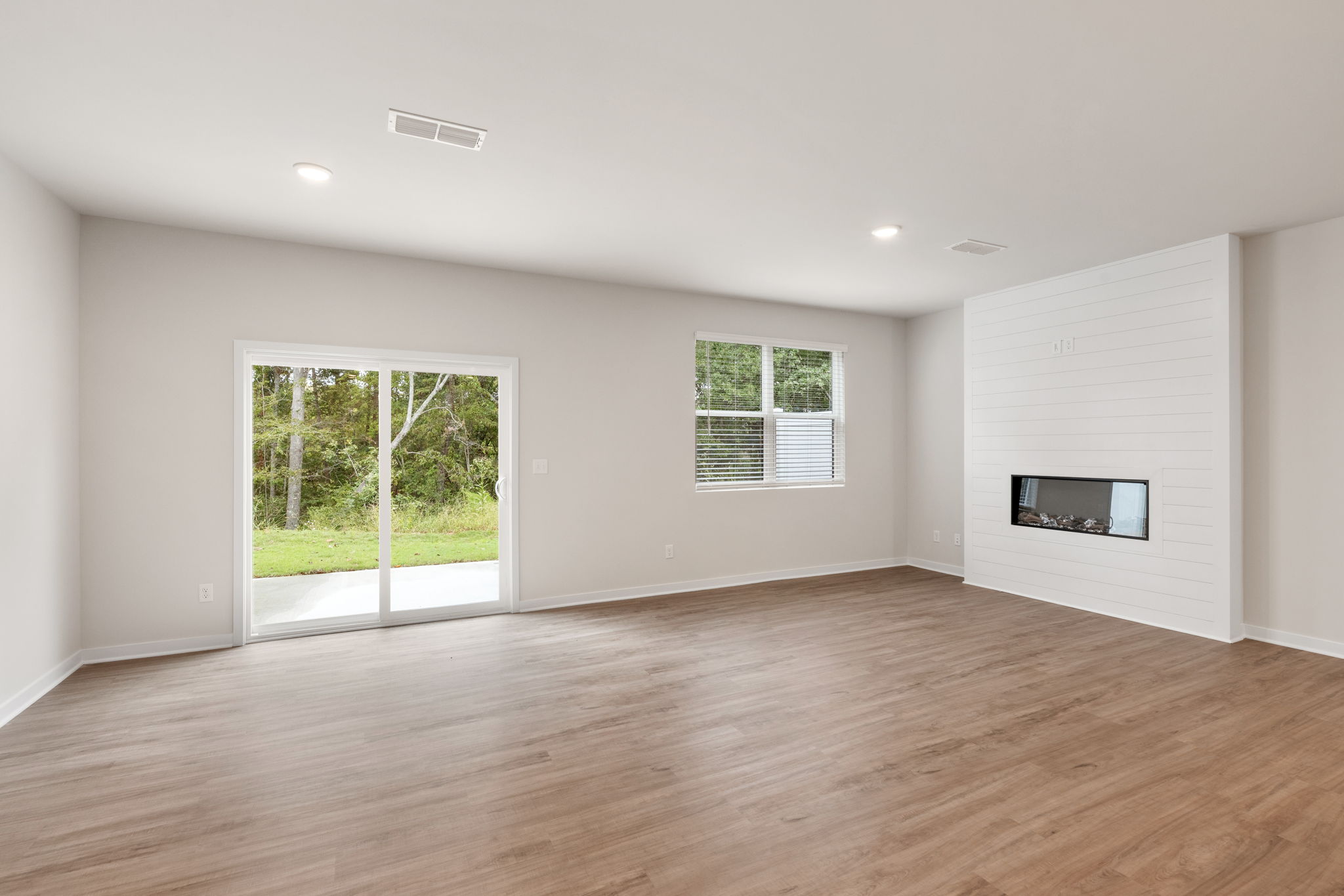 A room with a wood floor and a wood floor with a fireplace.