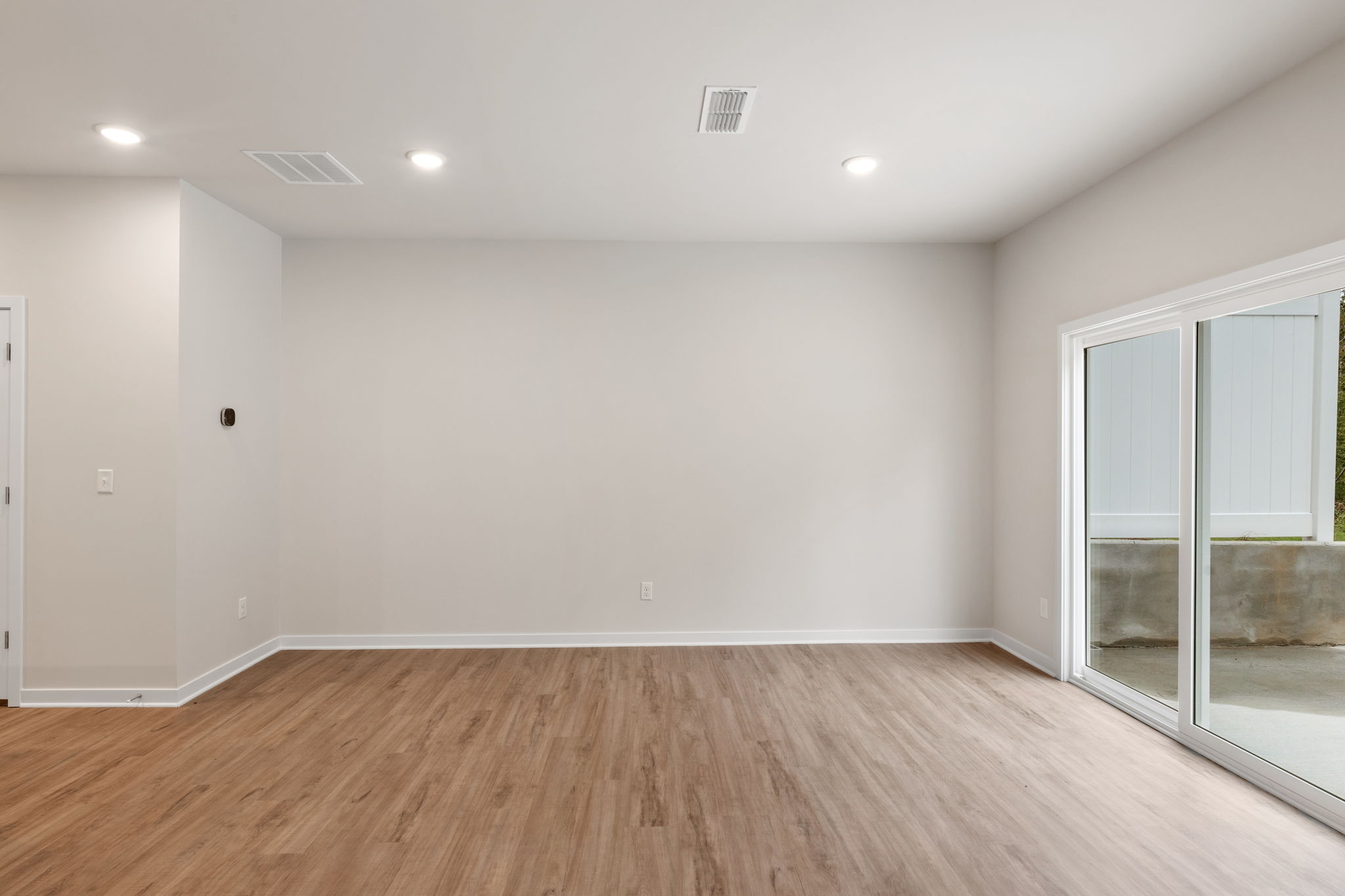 A room with a wood floor and a glass door.
