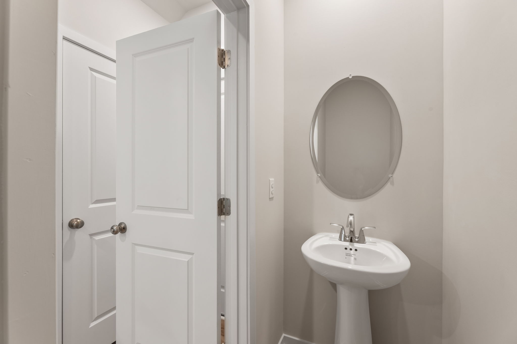 A bathroom with a round mirror.