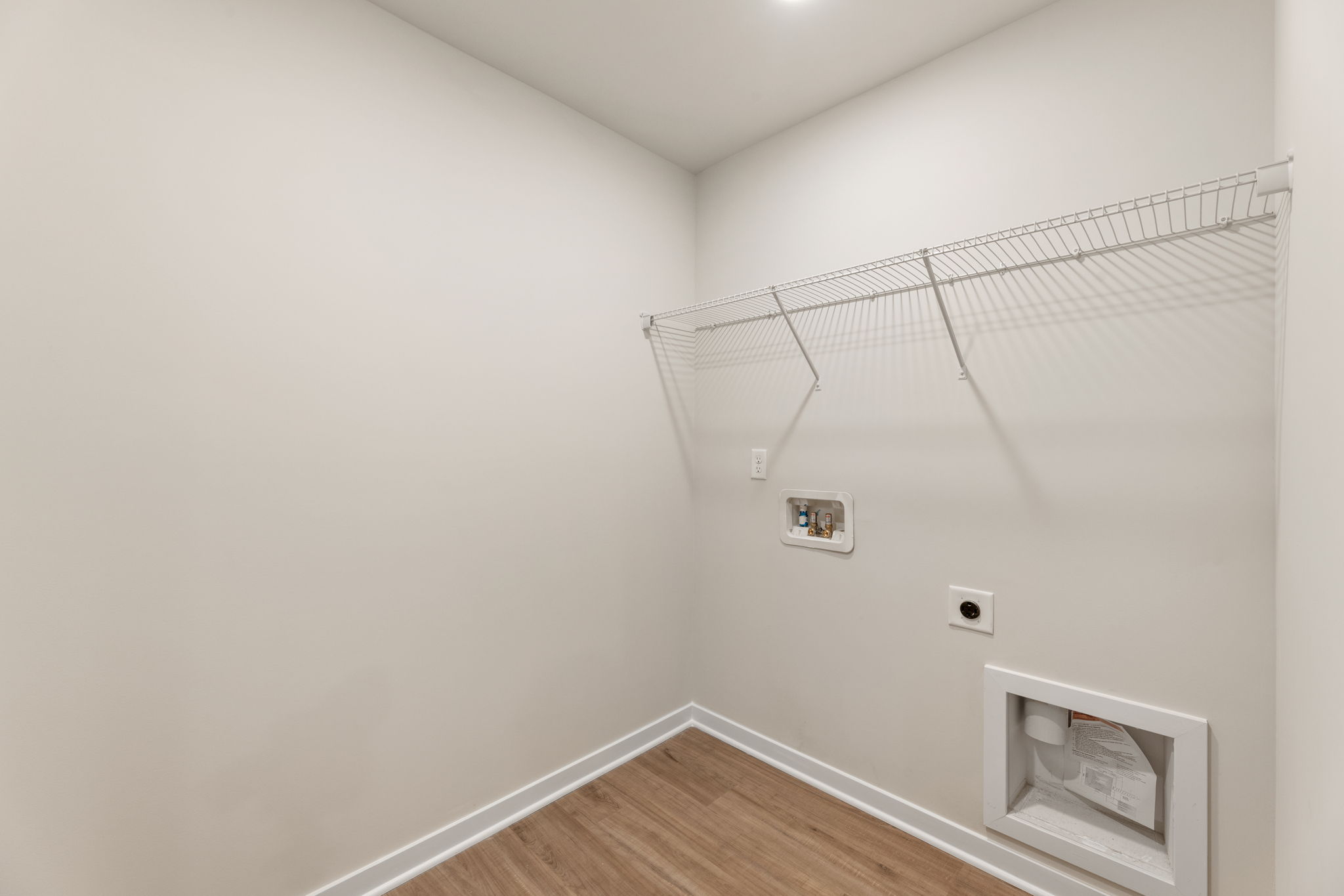 A white room with a wood floor and a wood floor.
