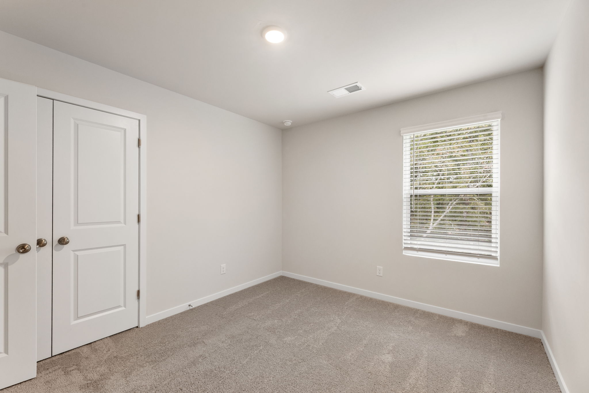 A room with white walls and a window.