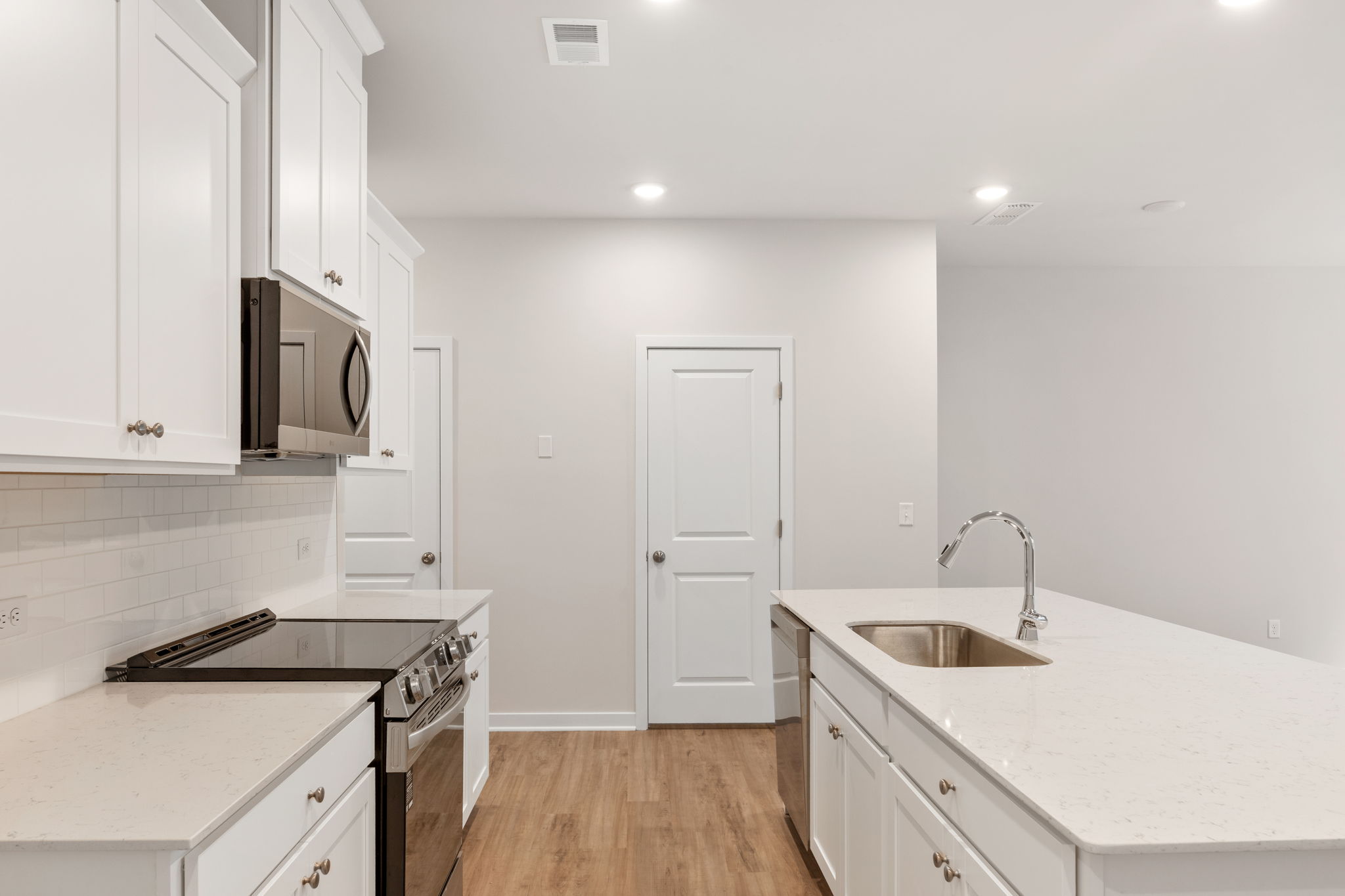 A kitchen with white cabinets.