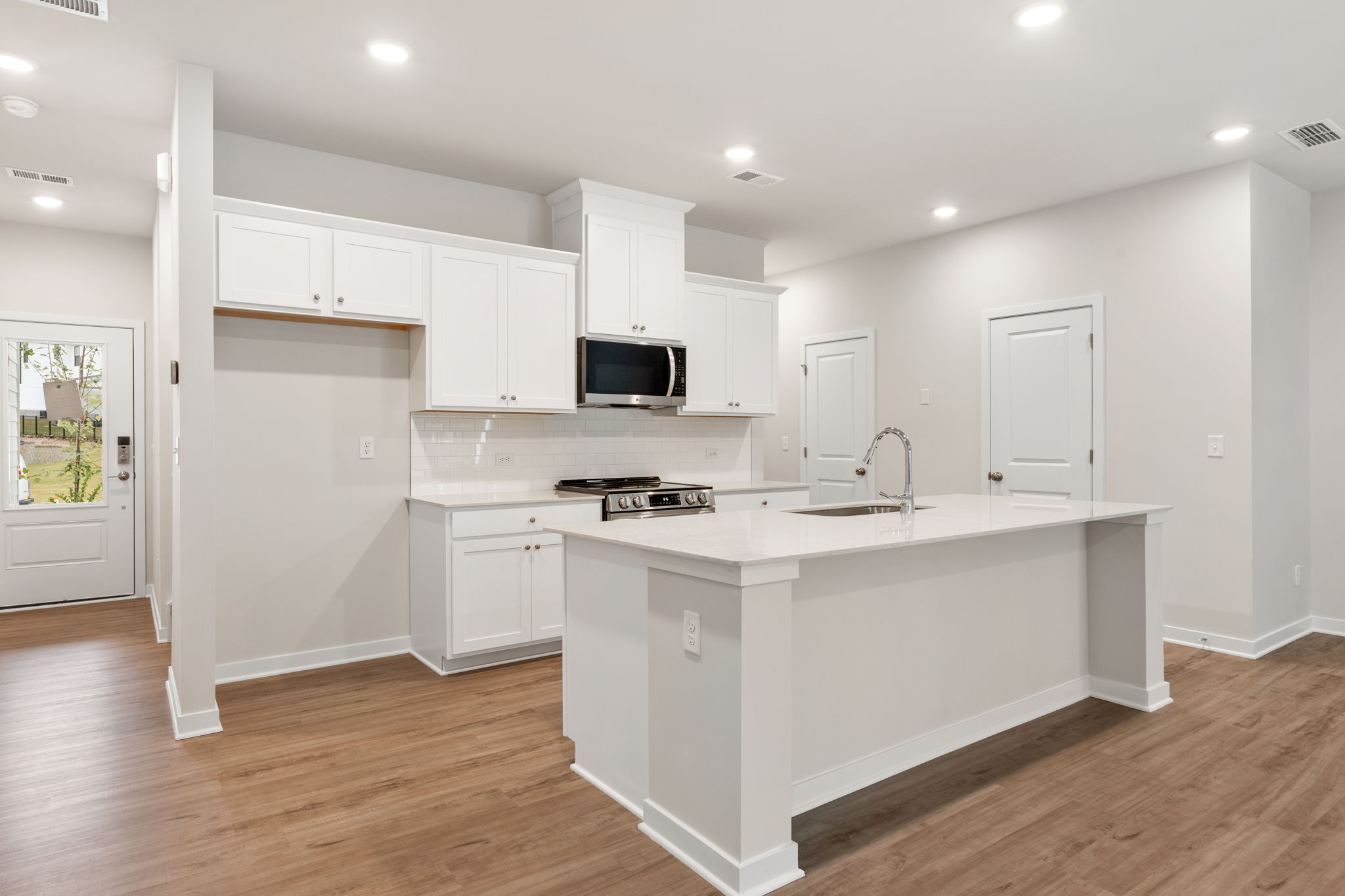 A kitchen with white cabinets.