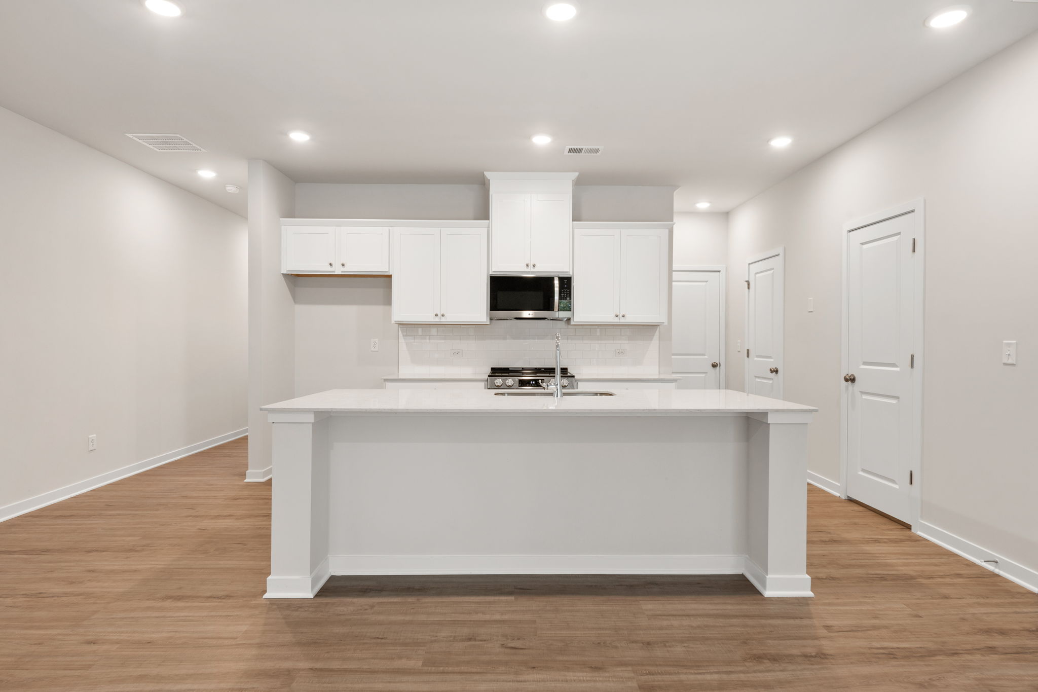 A kitchen with white cabinets.