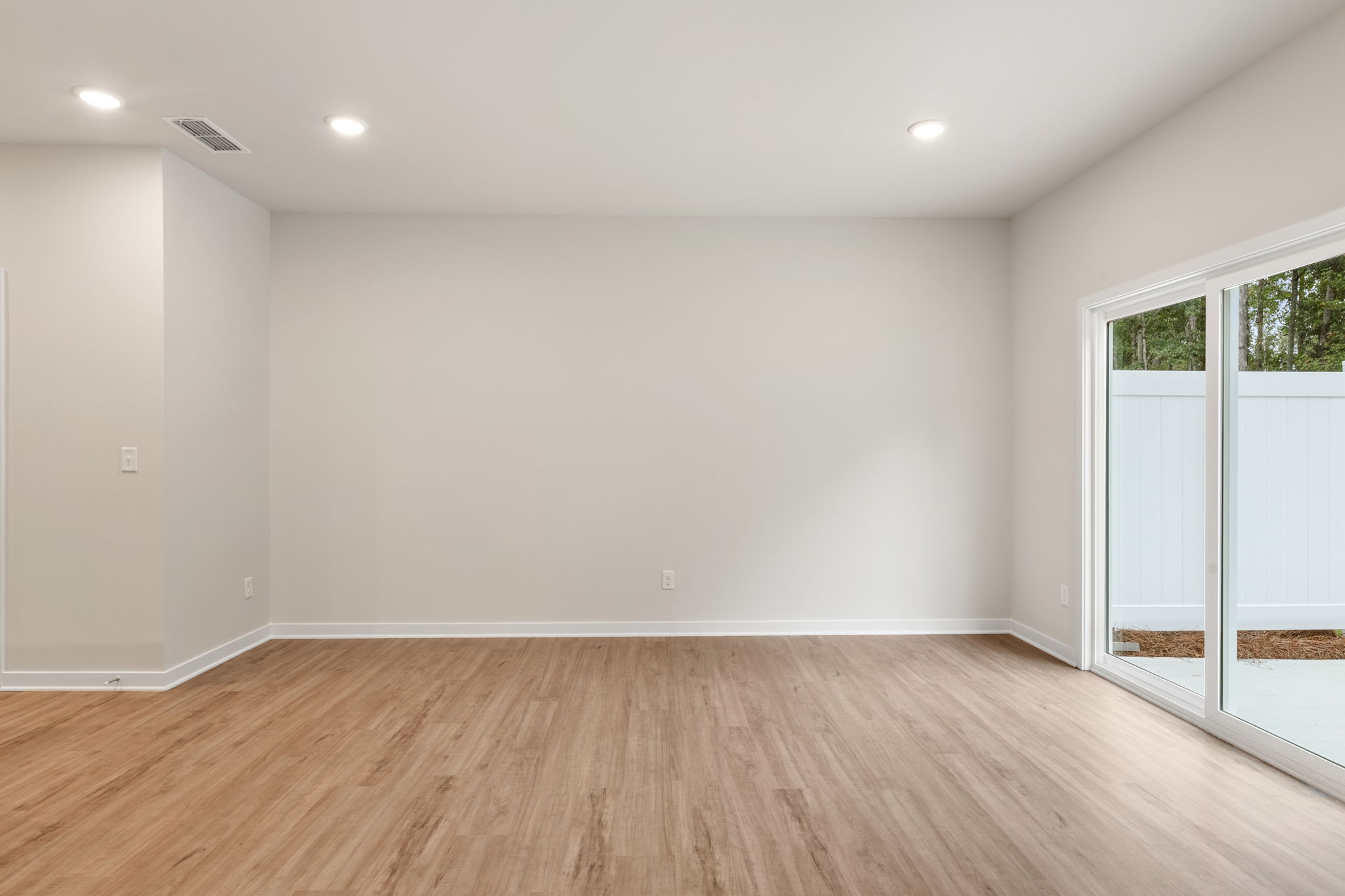 A room with a wood floor and a glass door.