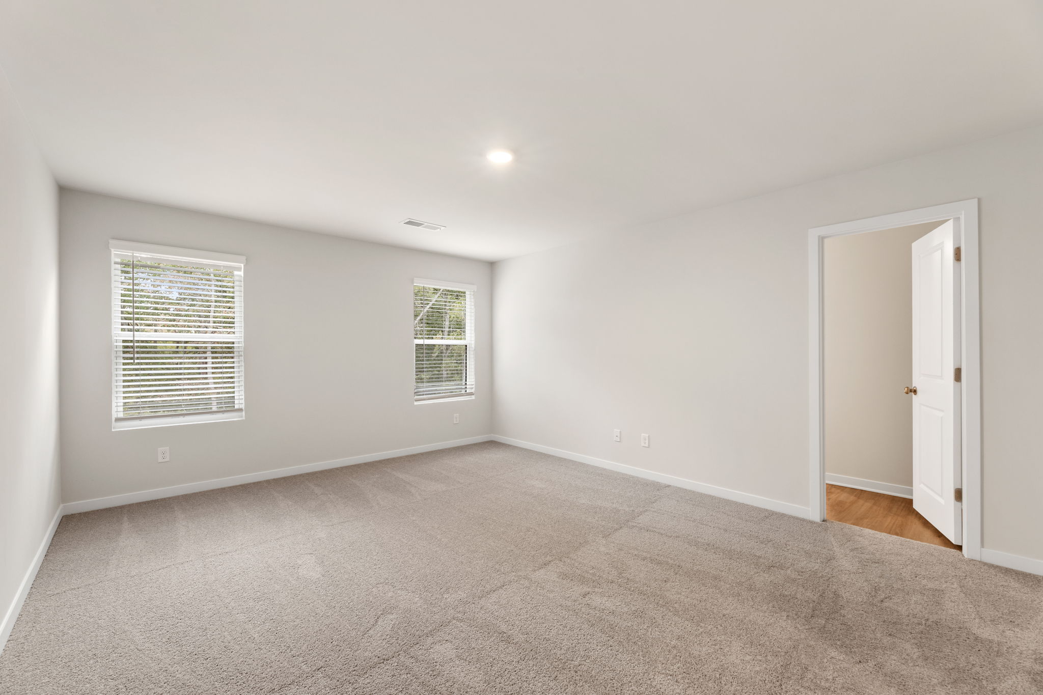 A room with a carpet and a door.