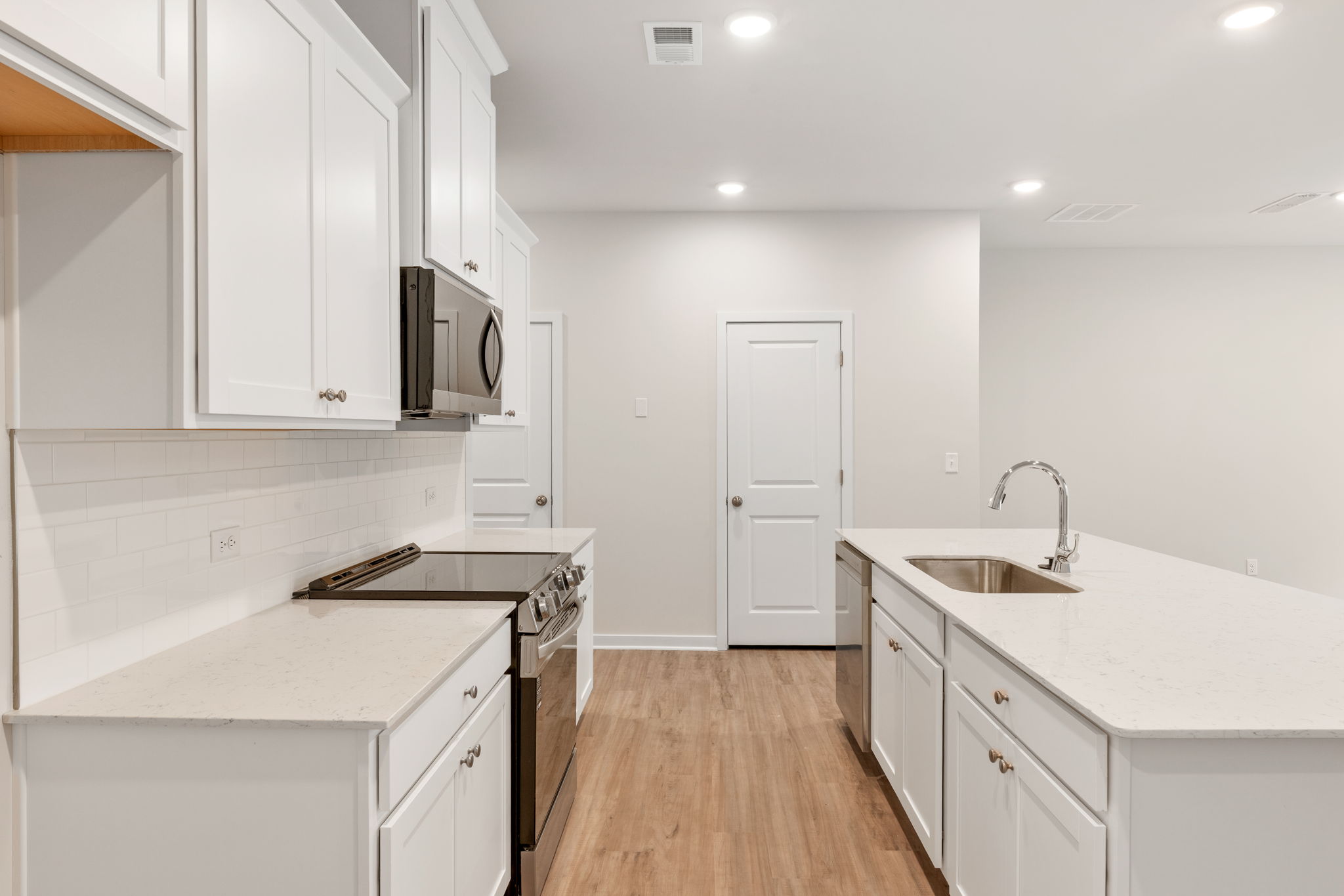A kitchen with white cabinets.
