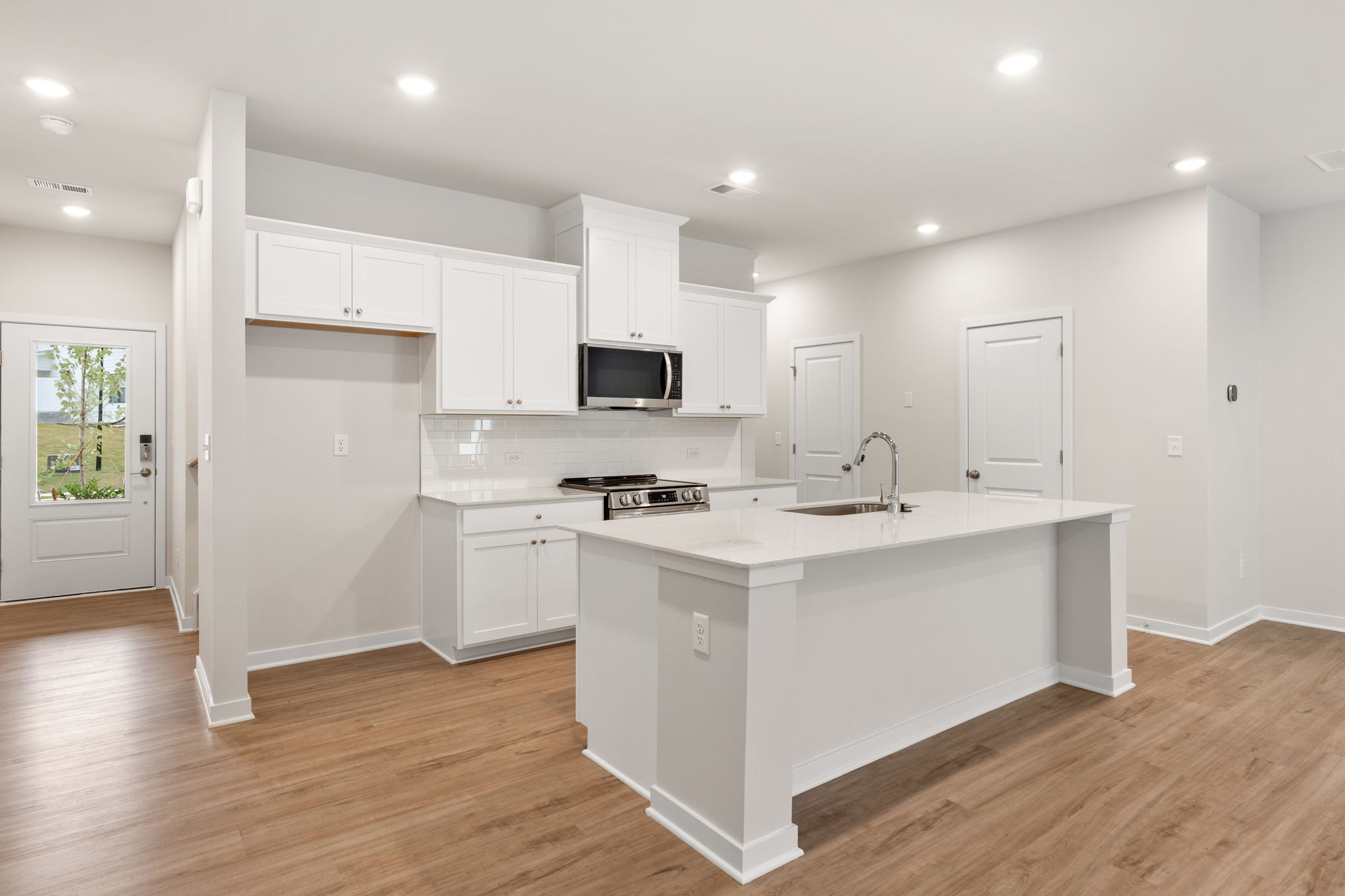 A kitchen with white cabinets.