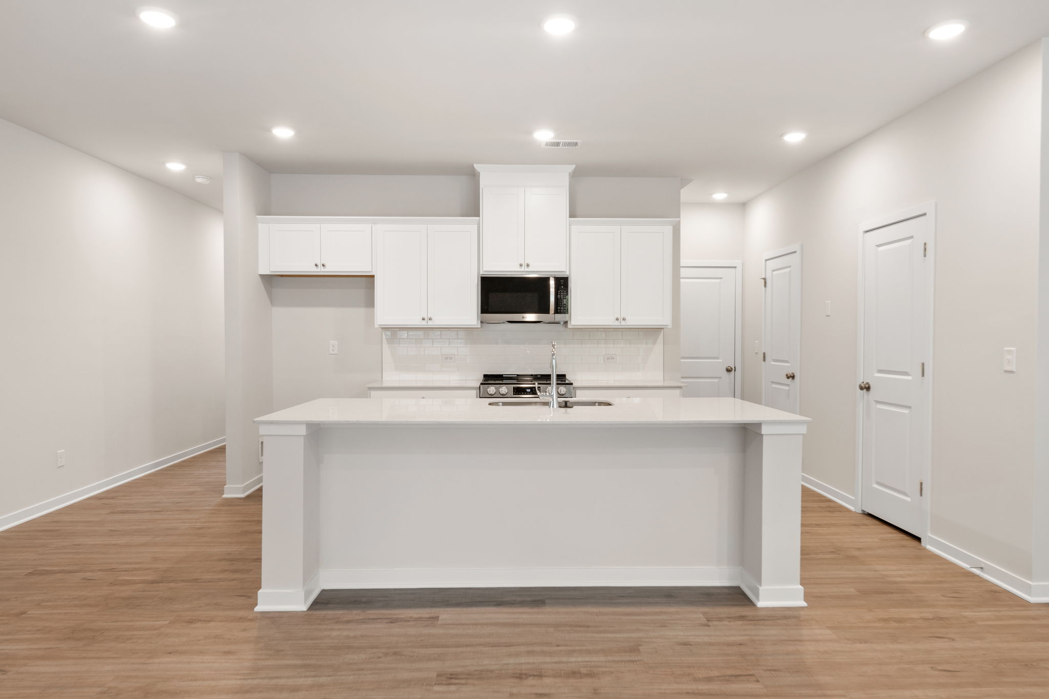 A kitchen with white cabinets.
