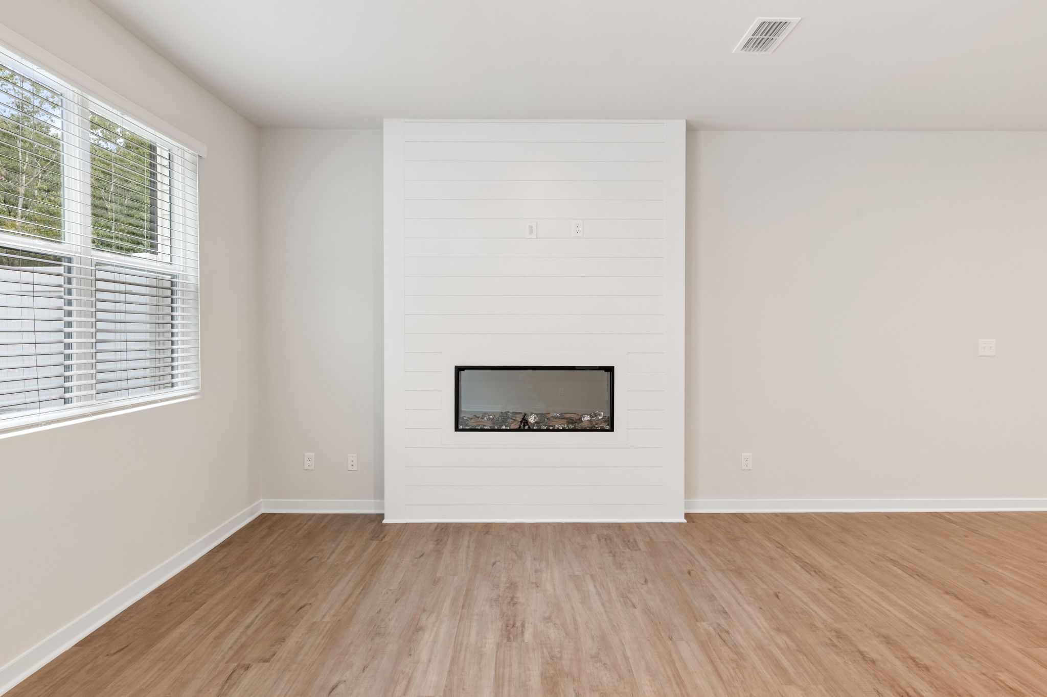 A room with a white wall and a window.