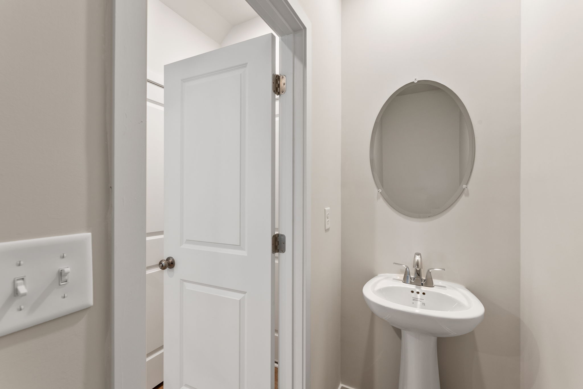 A bathroom with a round mirror.