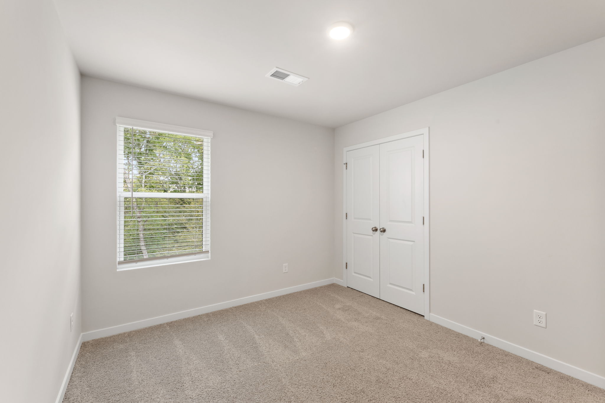 A room with white walls and a window.