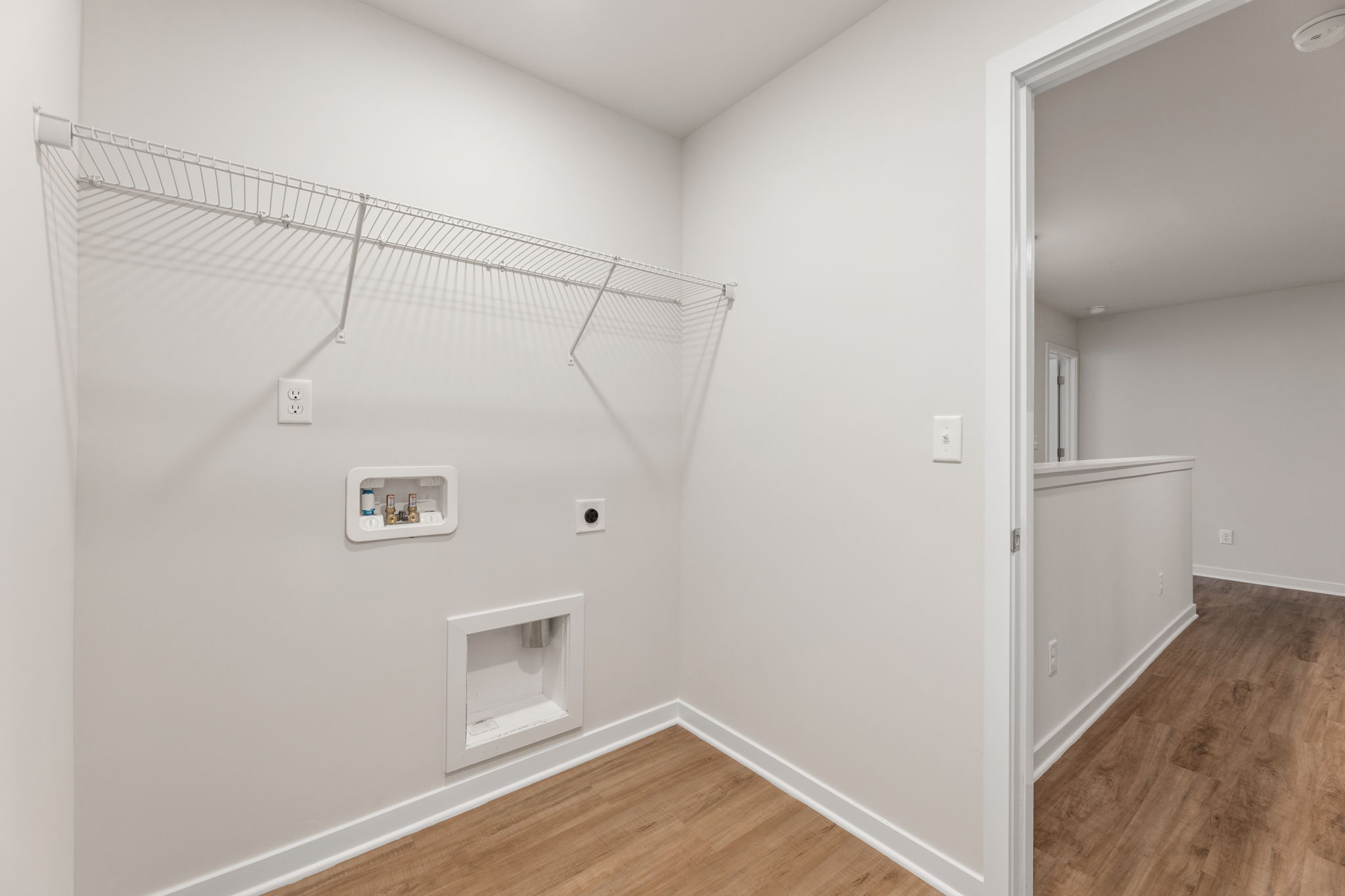 A white room with a wood floor.