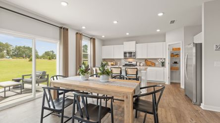 A kitchen with a dining table and chairs.