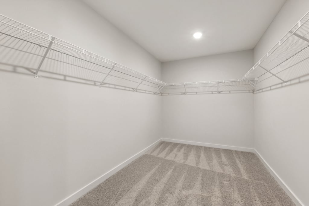 A white hallway with a rug.