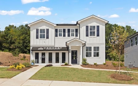 A white building with a lawn in front of it.