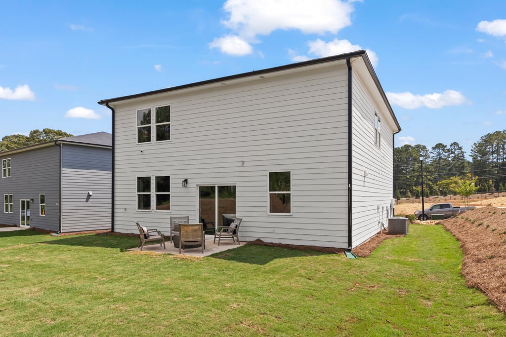 A house with a lawn and chairs.