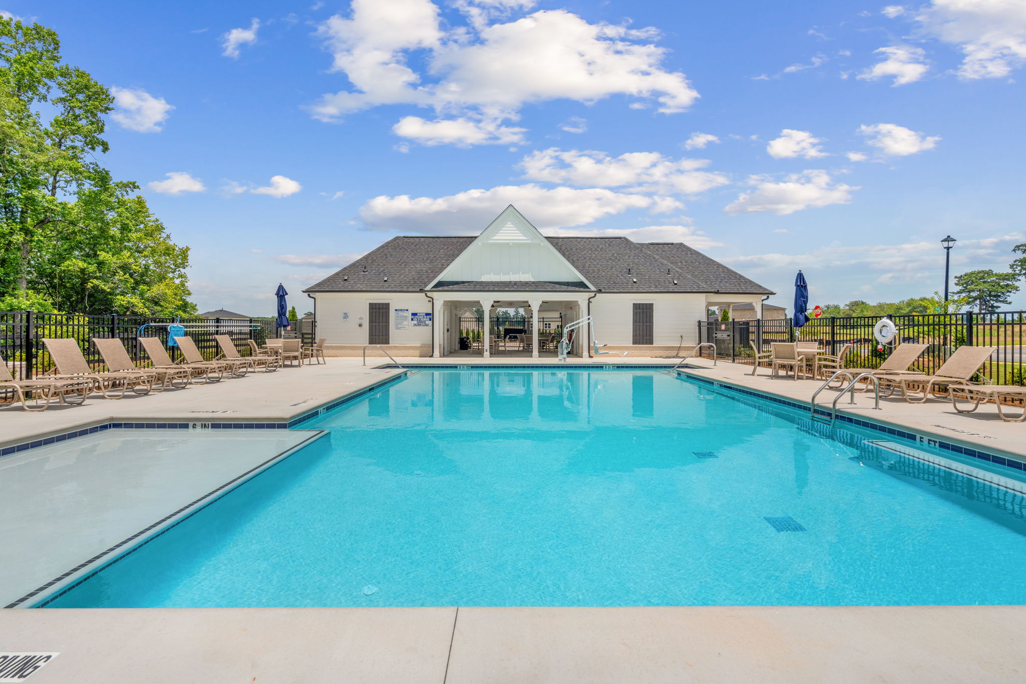 A swimming pool with a house in the background.