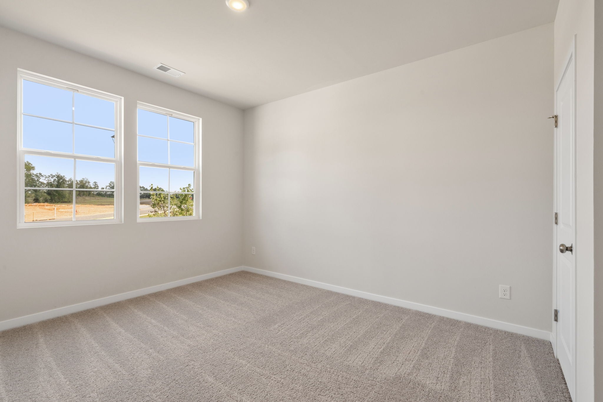 A room with a window and a carpet.