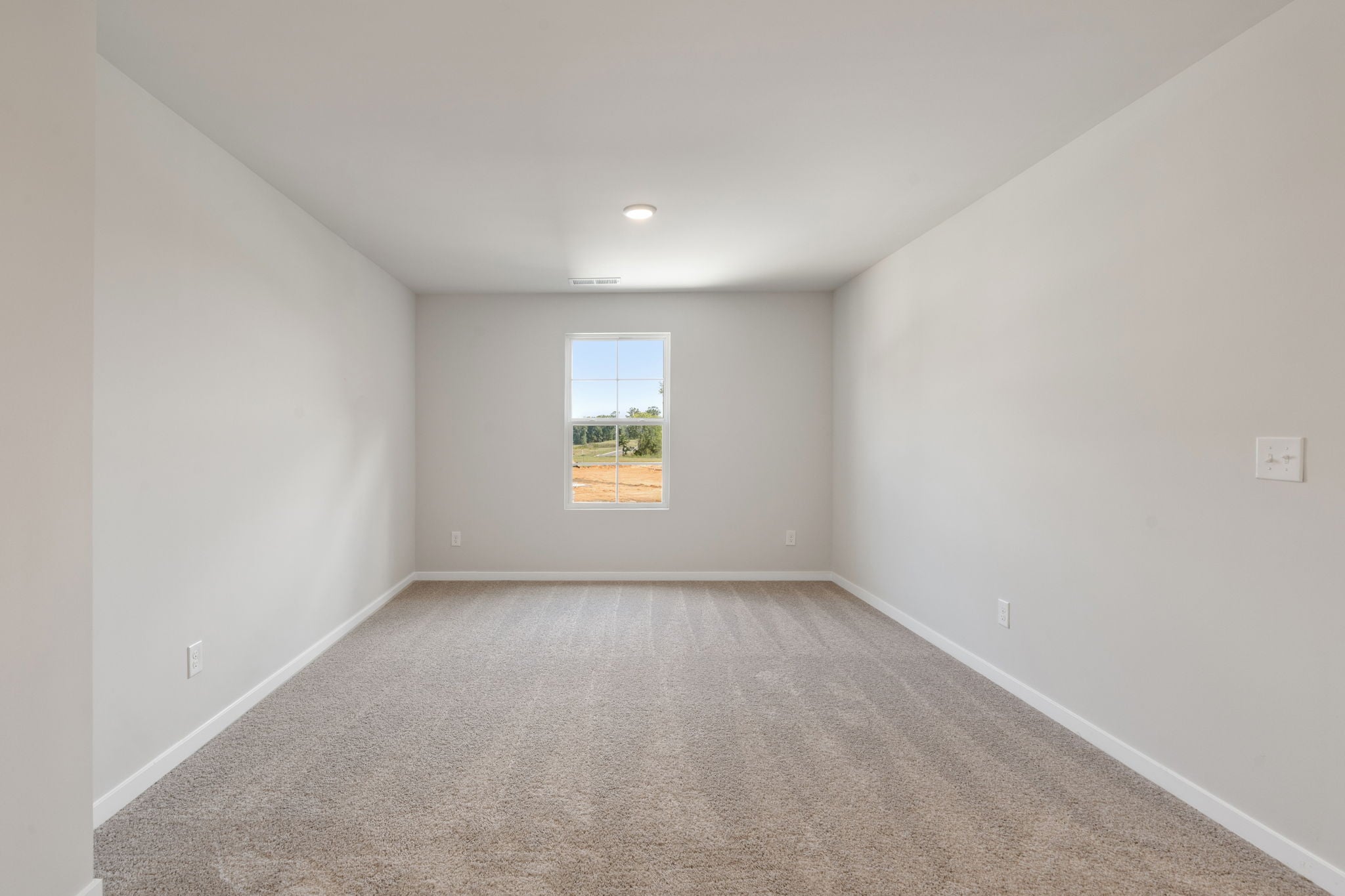 A room with a carpet and a window.